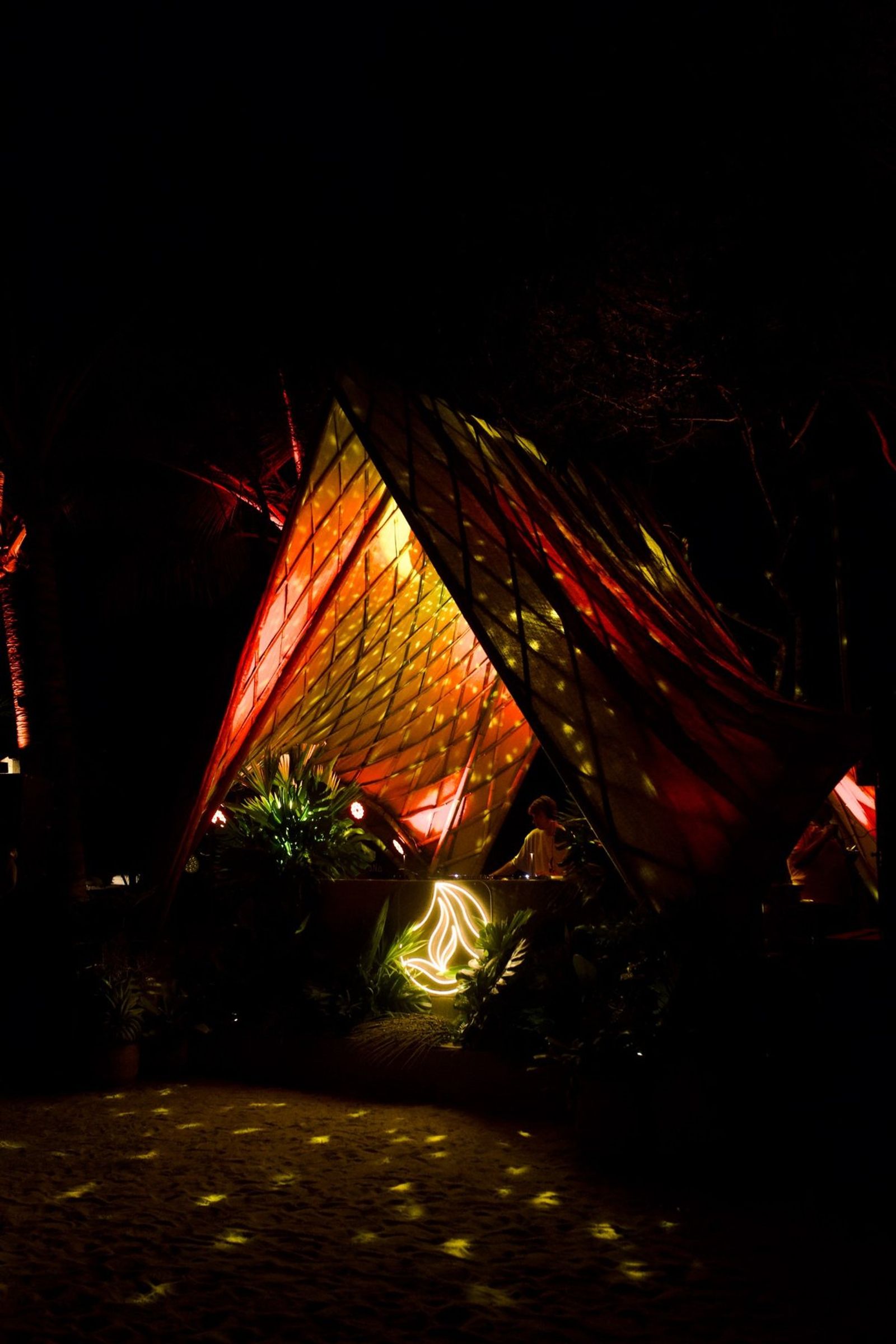 DJ sob a tenda iluminada à noite