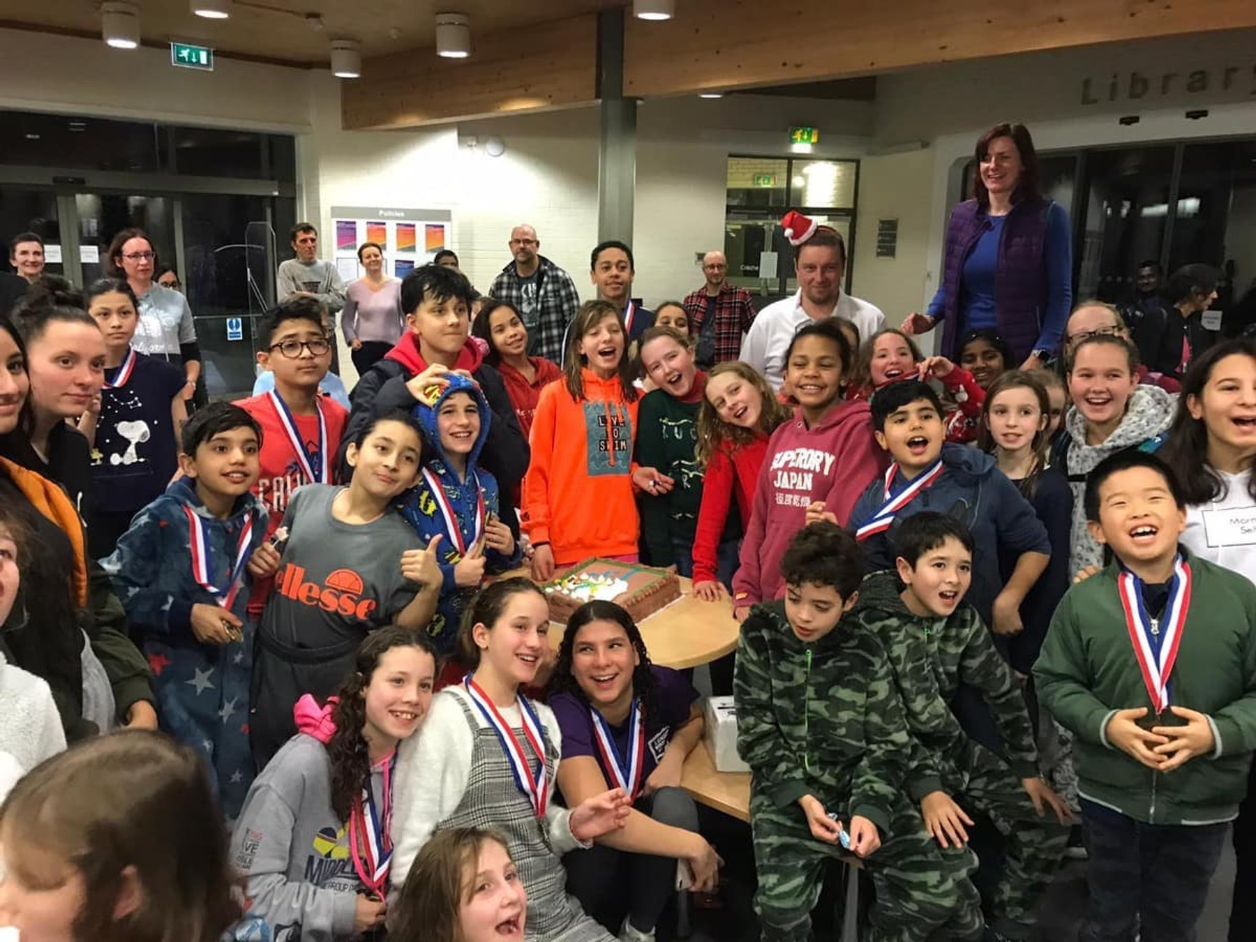 LBHSC swimmers and families celebrating with their medals after a gala