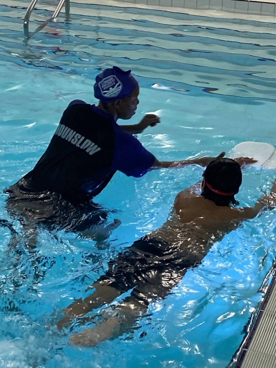 An LBHSC instructor in the water supporting a young swimmer with a float