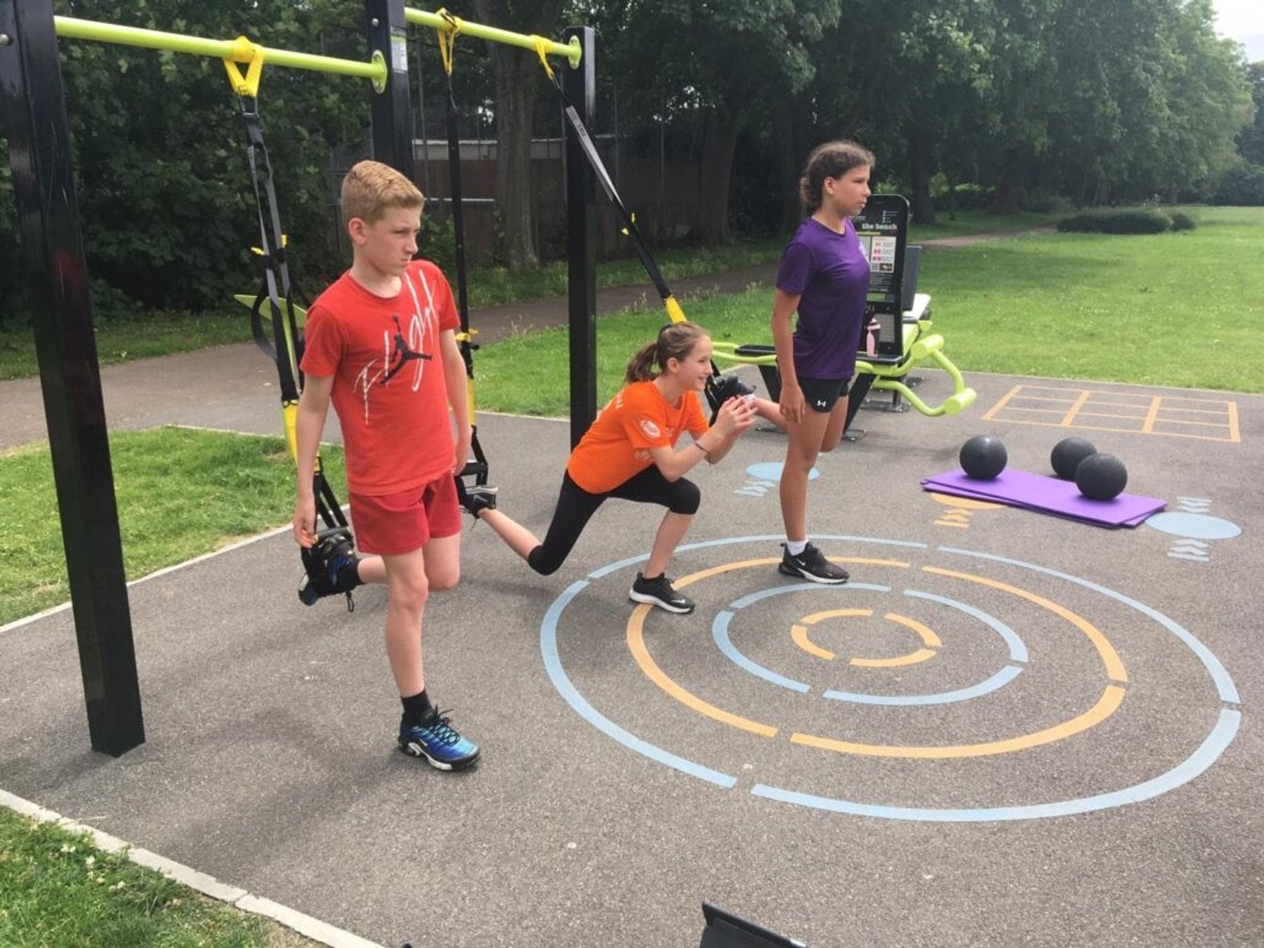 Young swimmers working through an outdoor strength circuit
