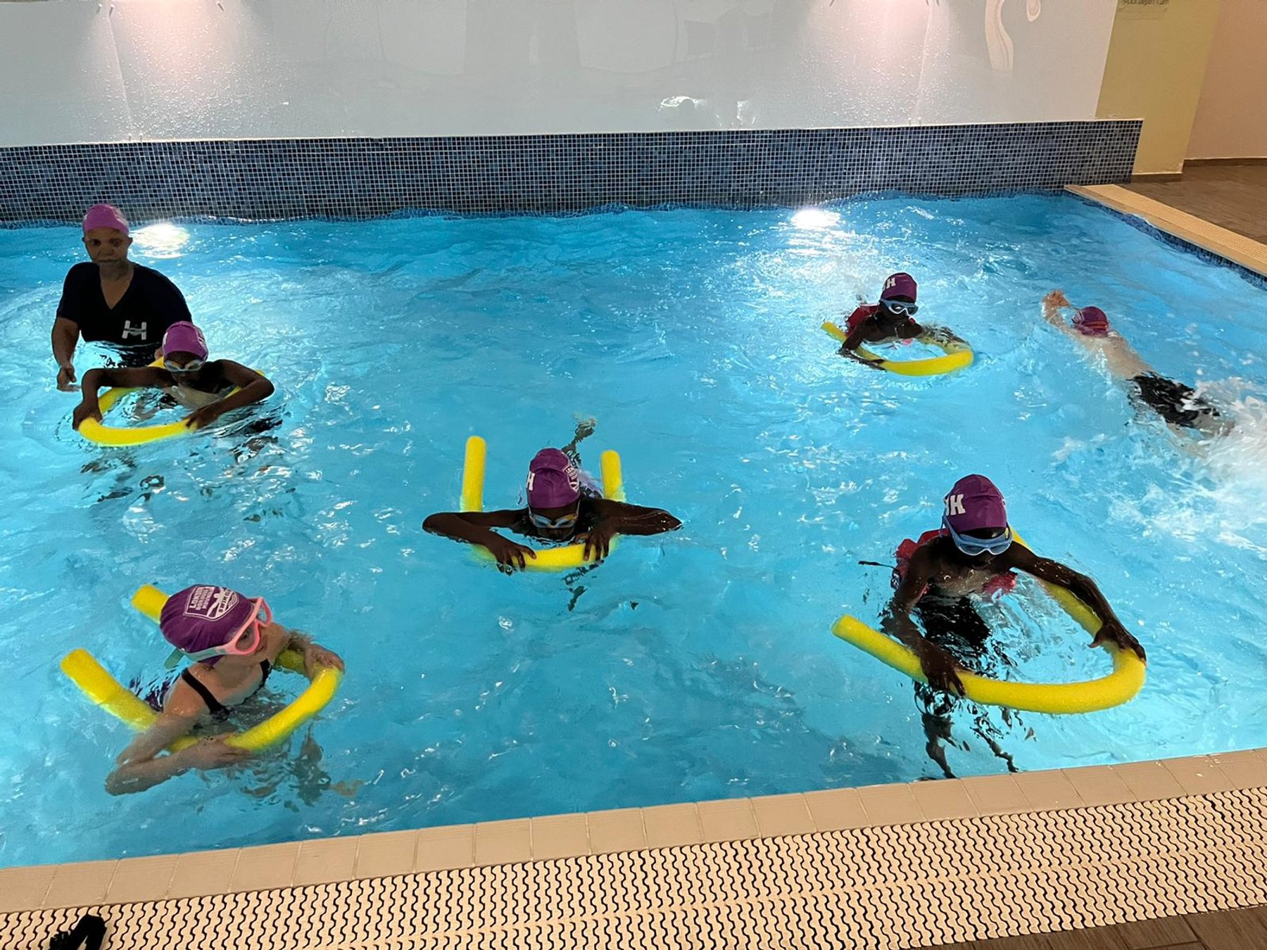 Community swimmers using noodles to build water confidence