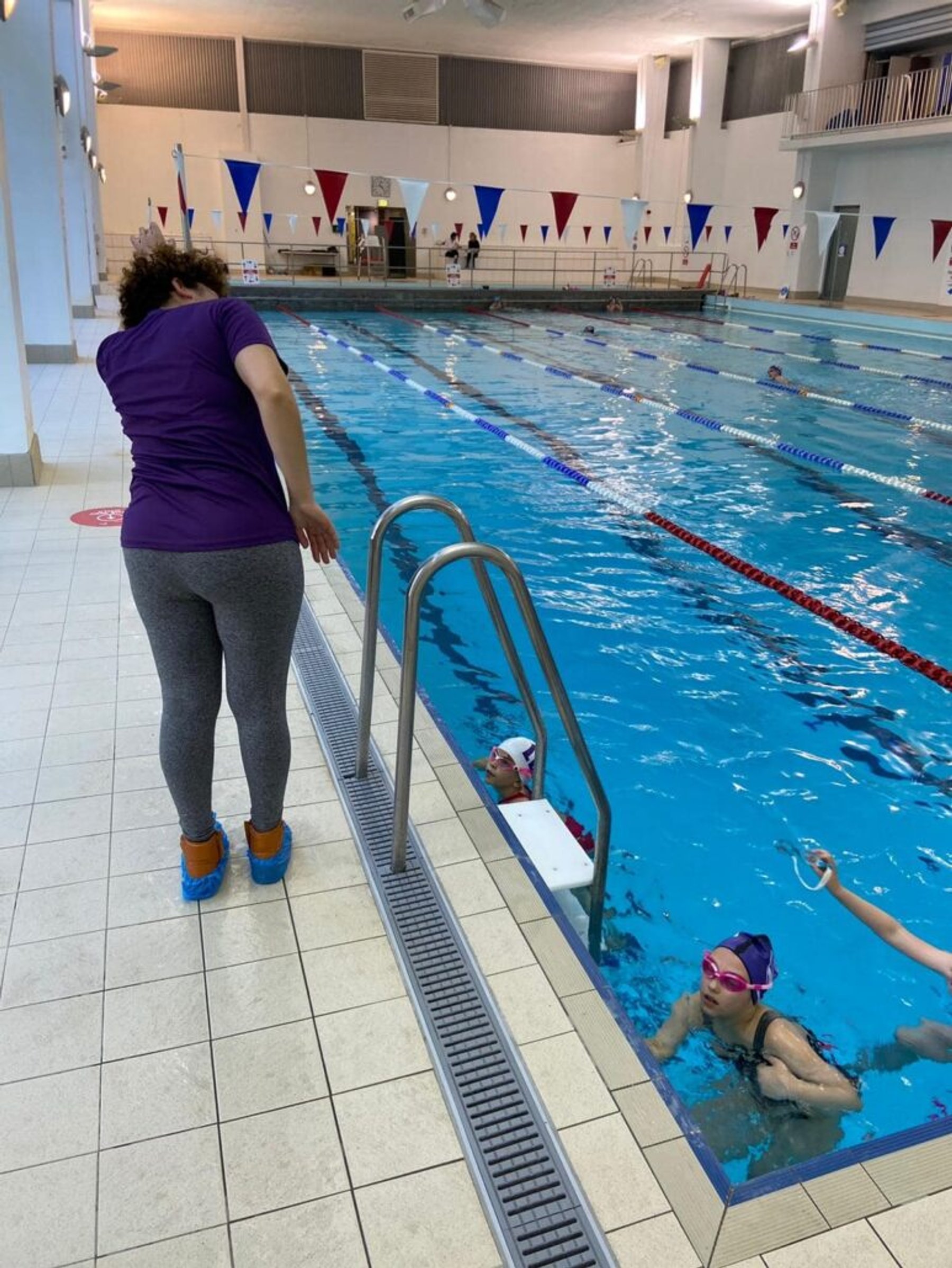 An LBHSC coach watching swimmers from the poolside