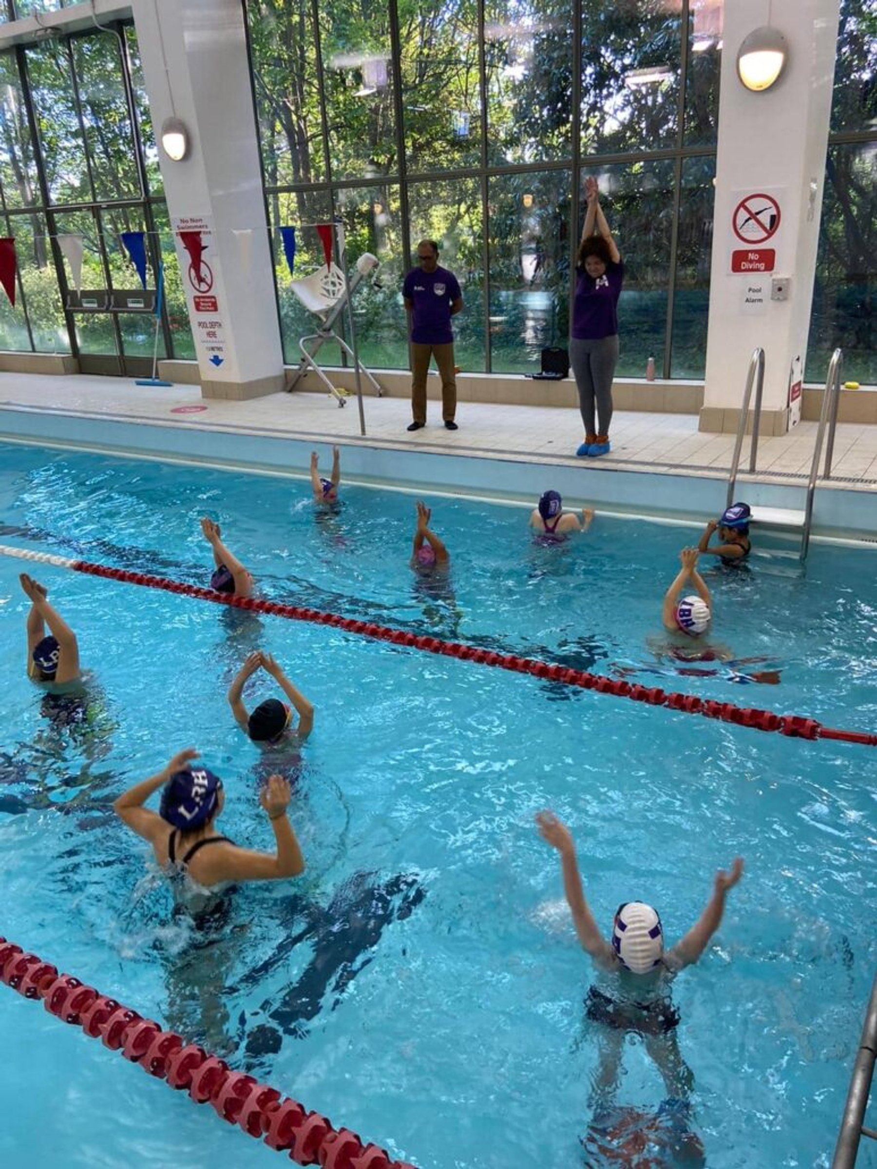 Squad swimmers practising drills in a training lane