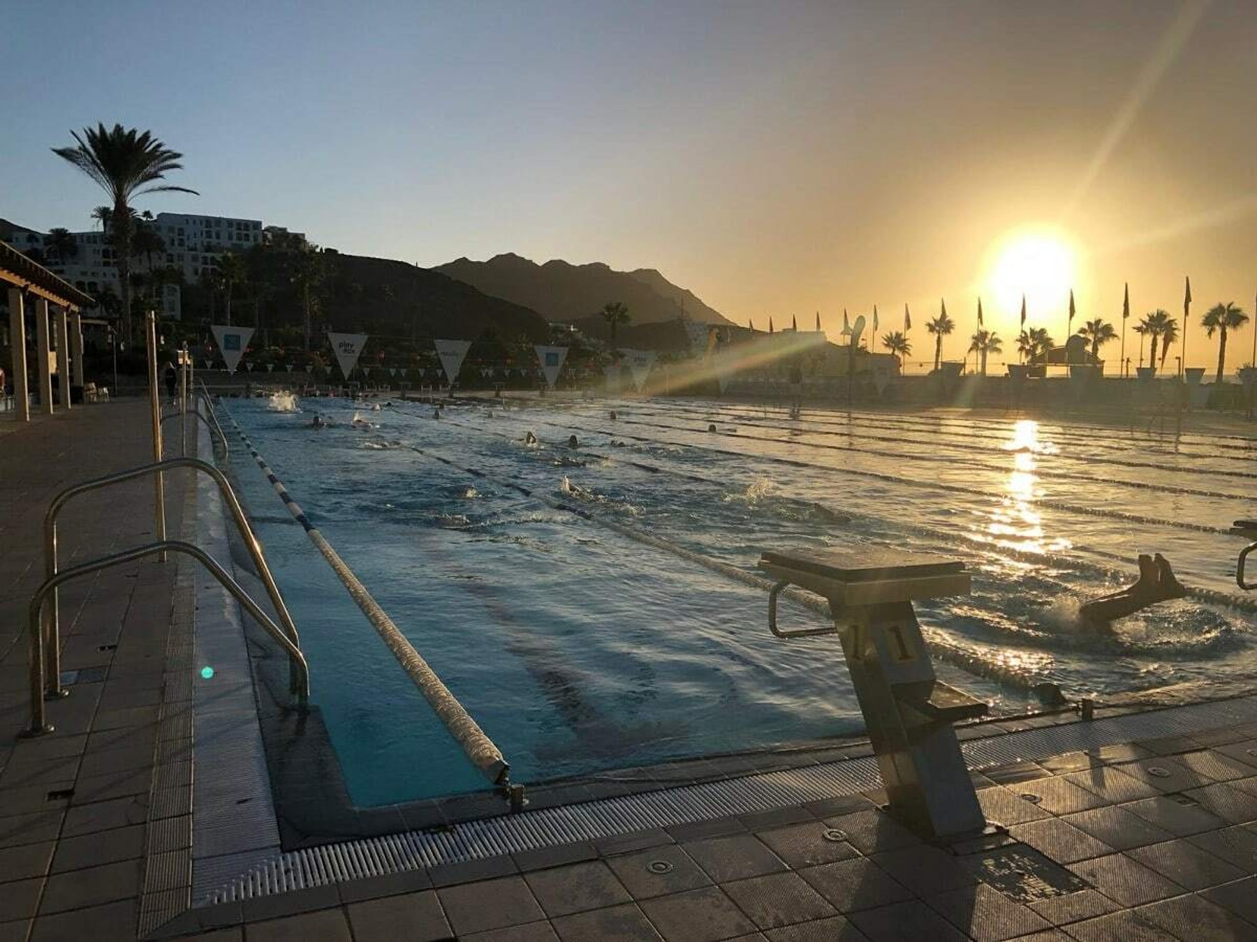 An outdoor training pool at sunset during swim camp