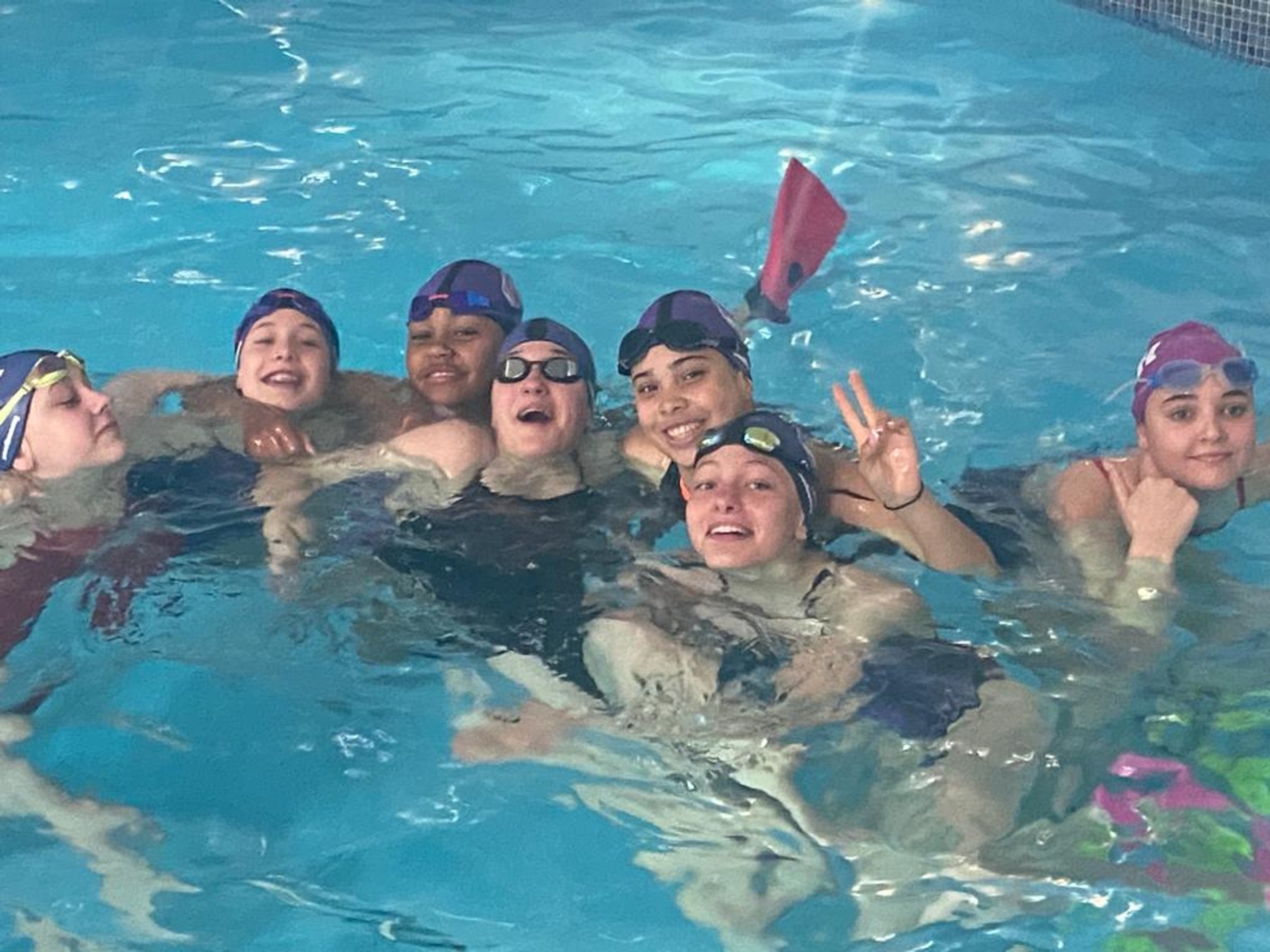 A group of smiling swimmers together in the pool