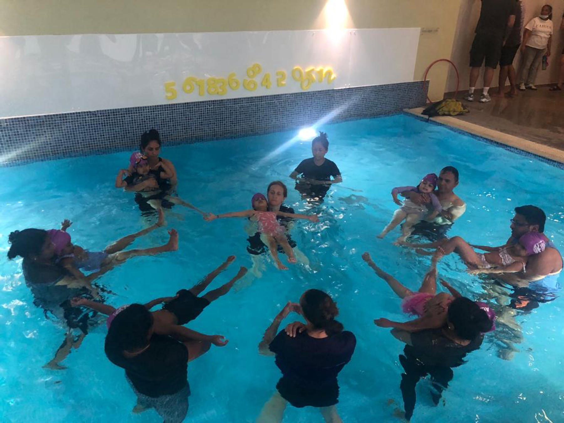 Swimmers in a circle during a community water confidence session