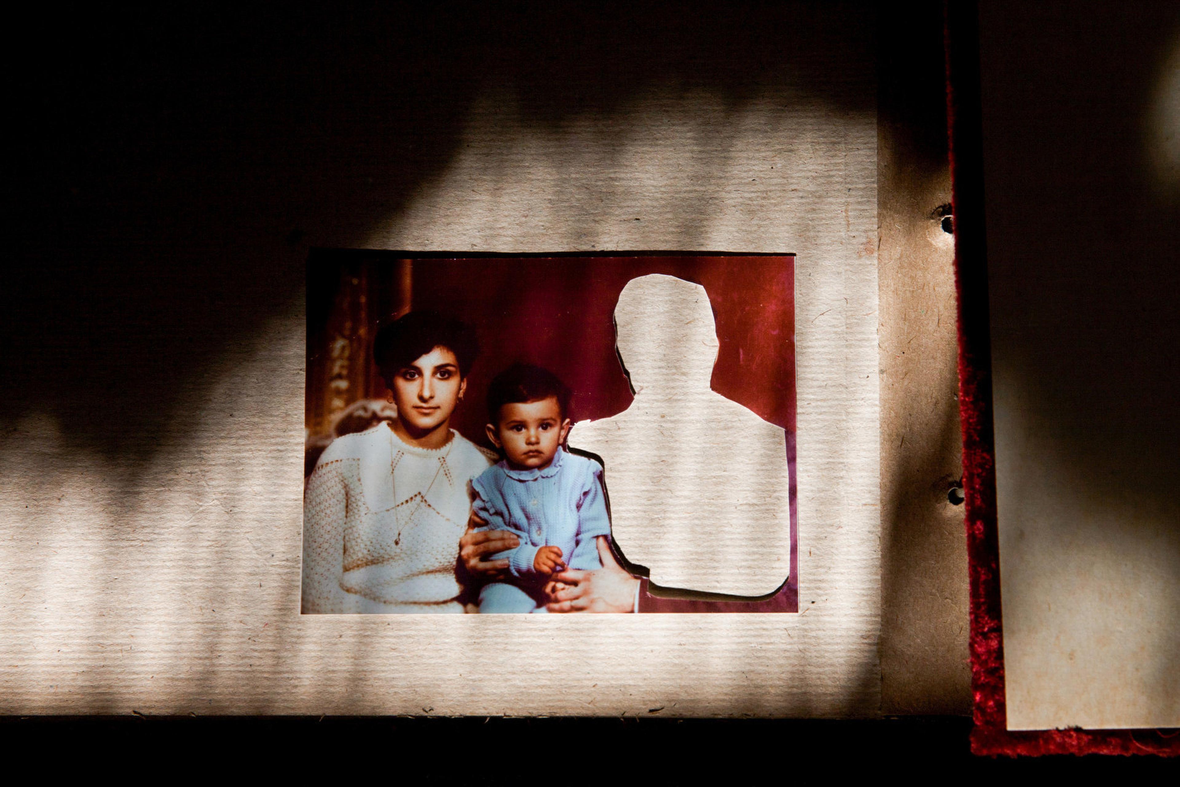Image of a family photo with a women and a daughter, while the father is cut out