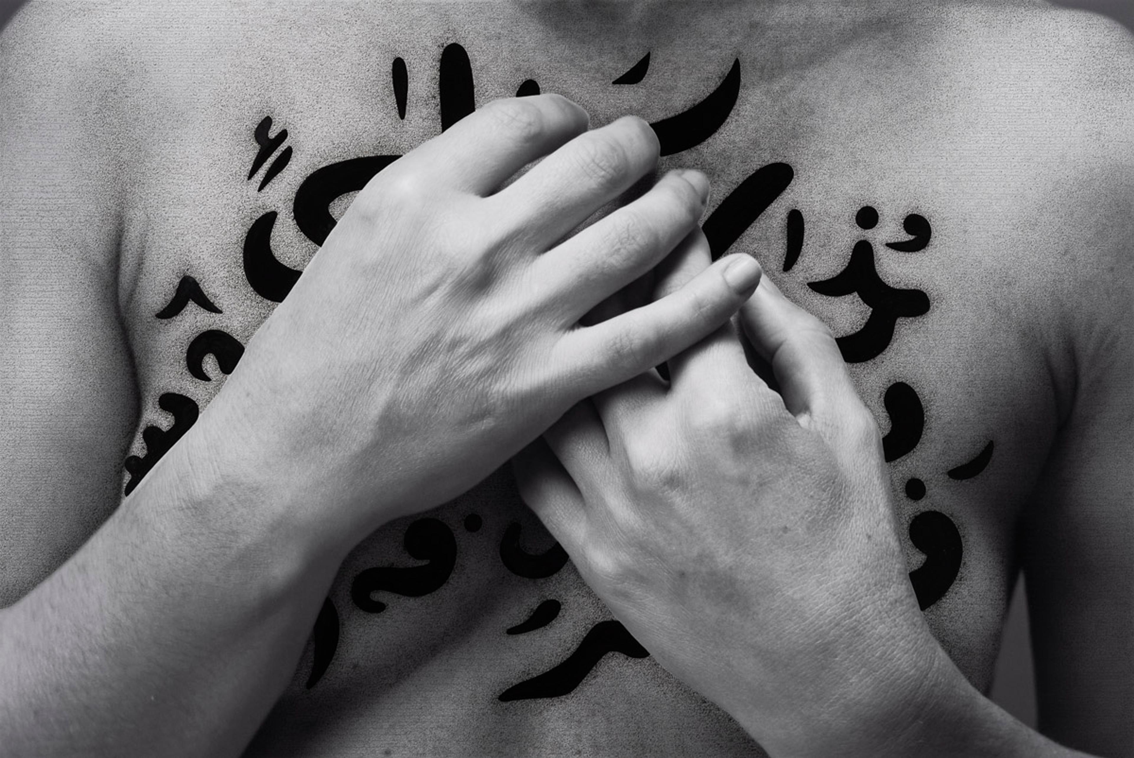 A person is clinching their hands to their chest
