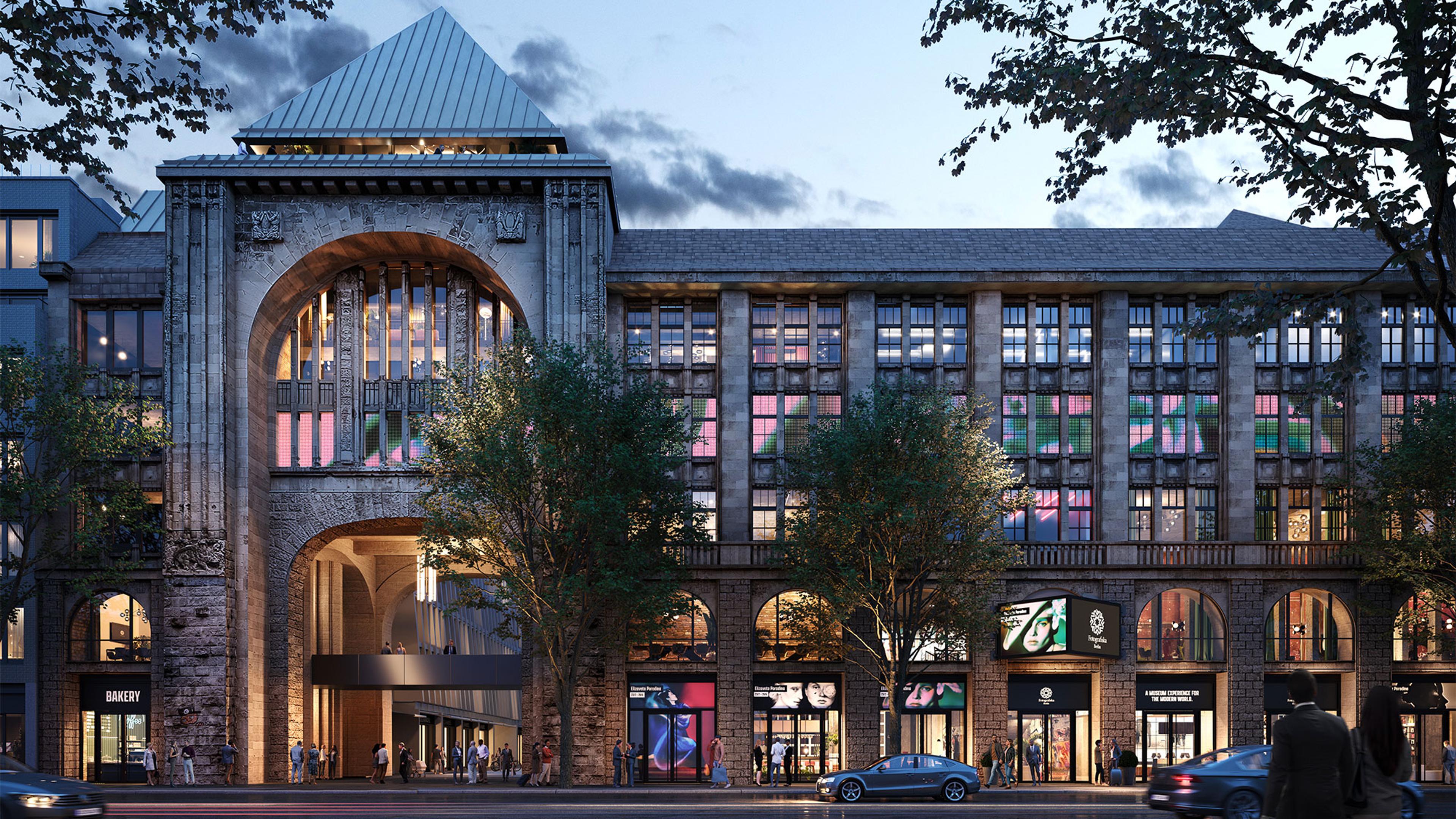 Photograph of a large building with many windows and people.