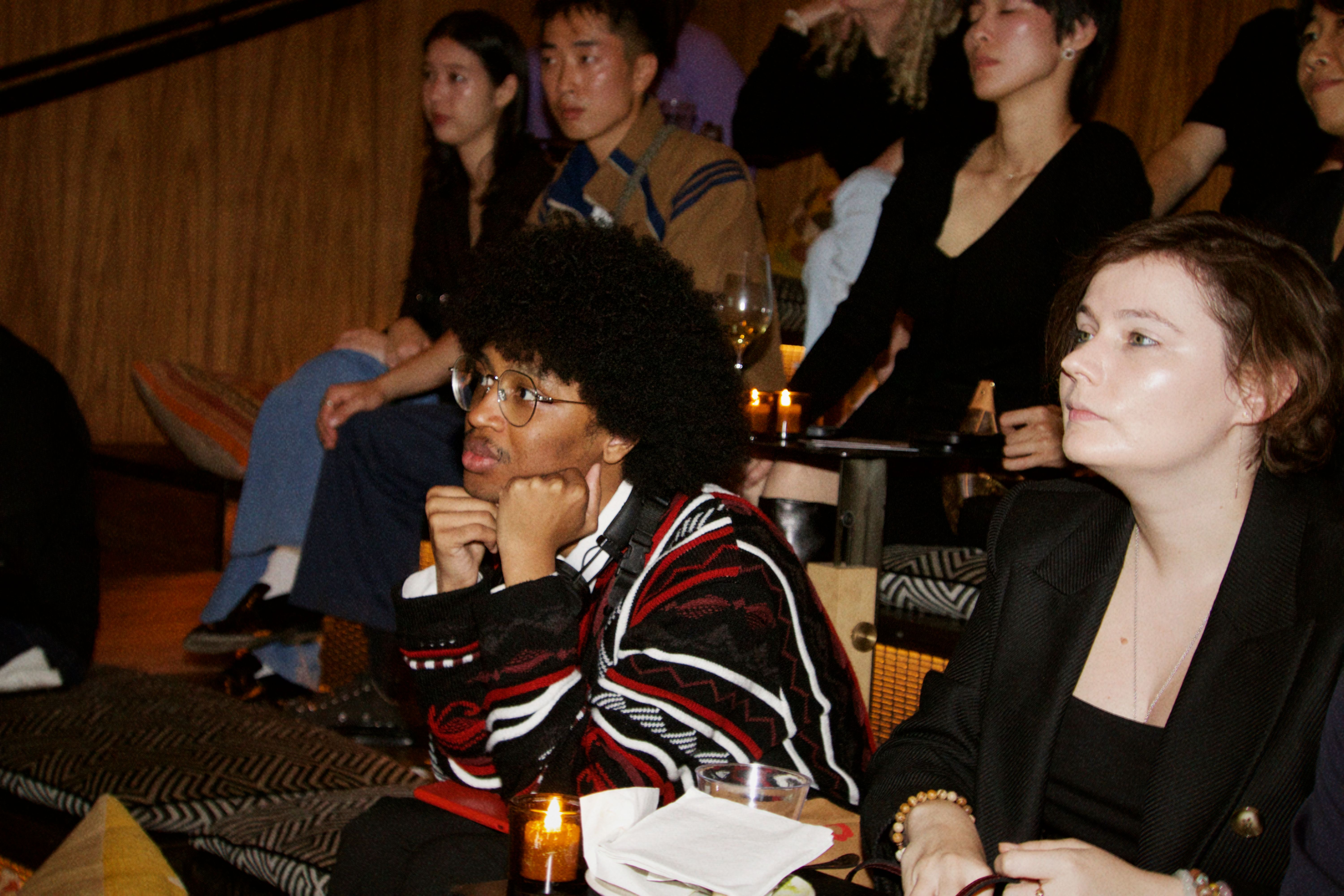 A guest listens intently with their face resting on their fists