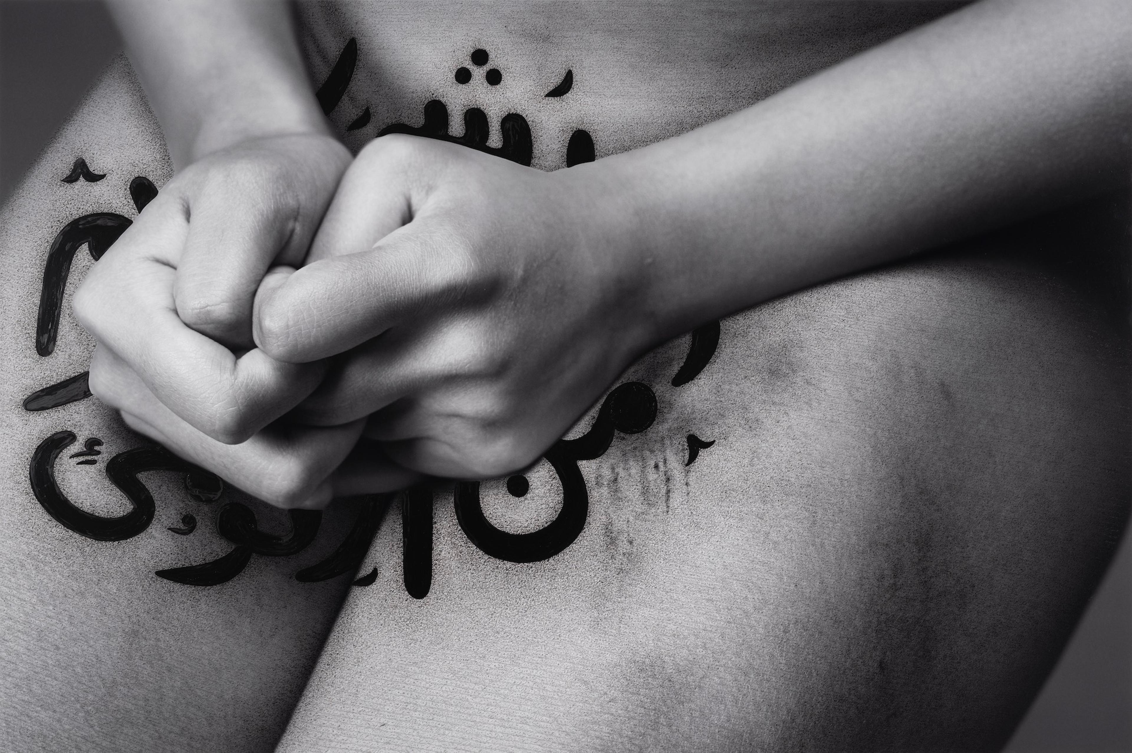 Close up of a nude female body with Iranian texts over her
