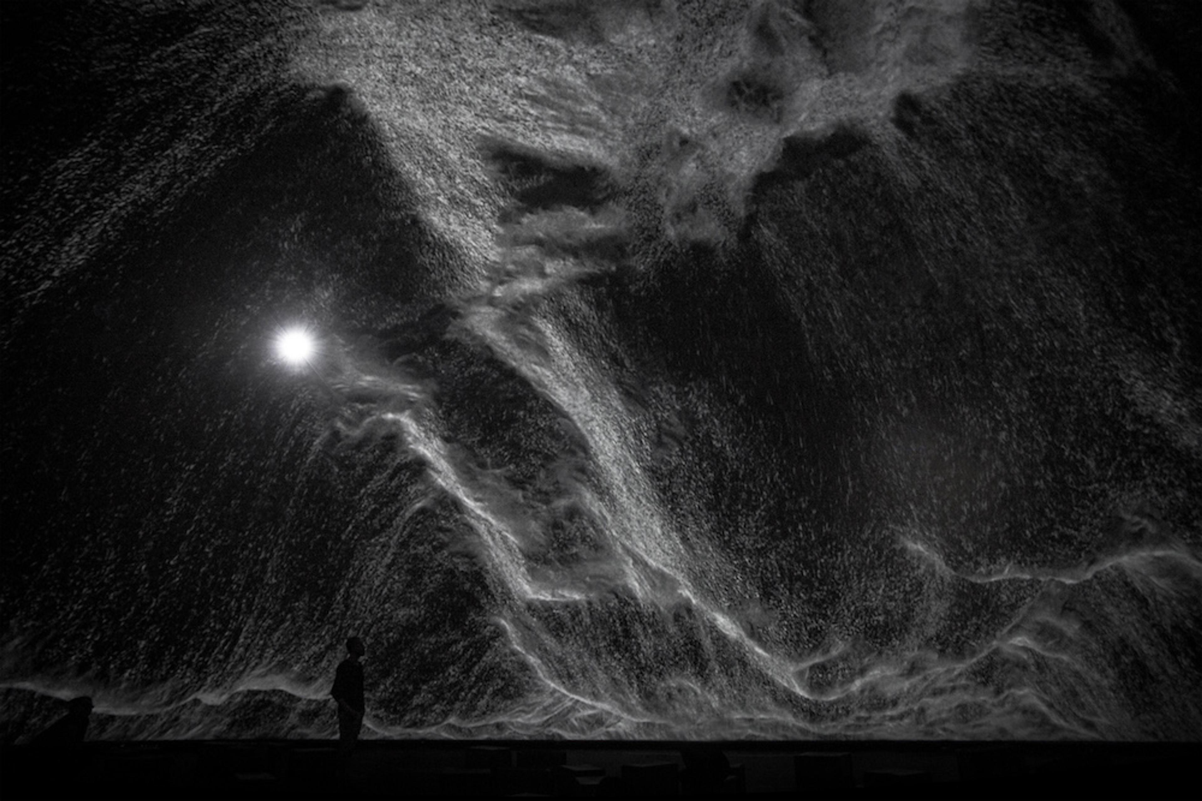 A moon behind a black sky.