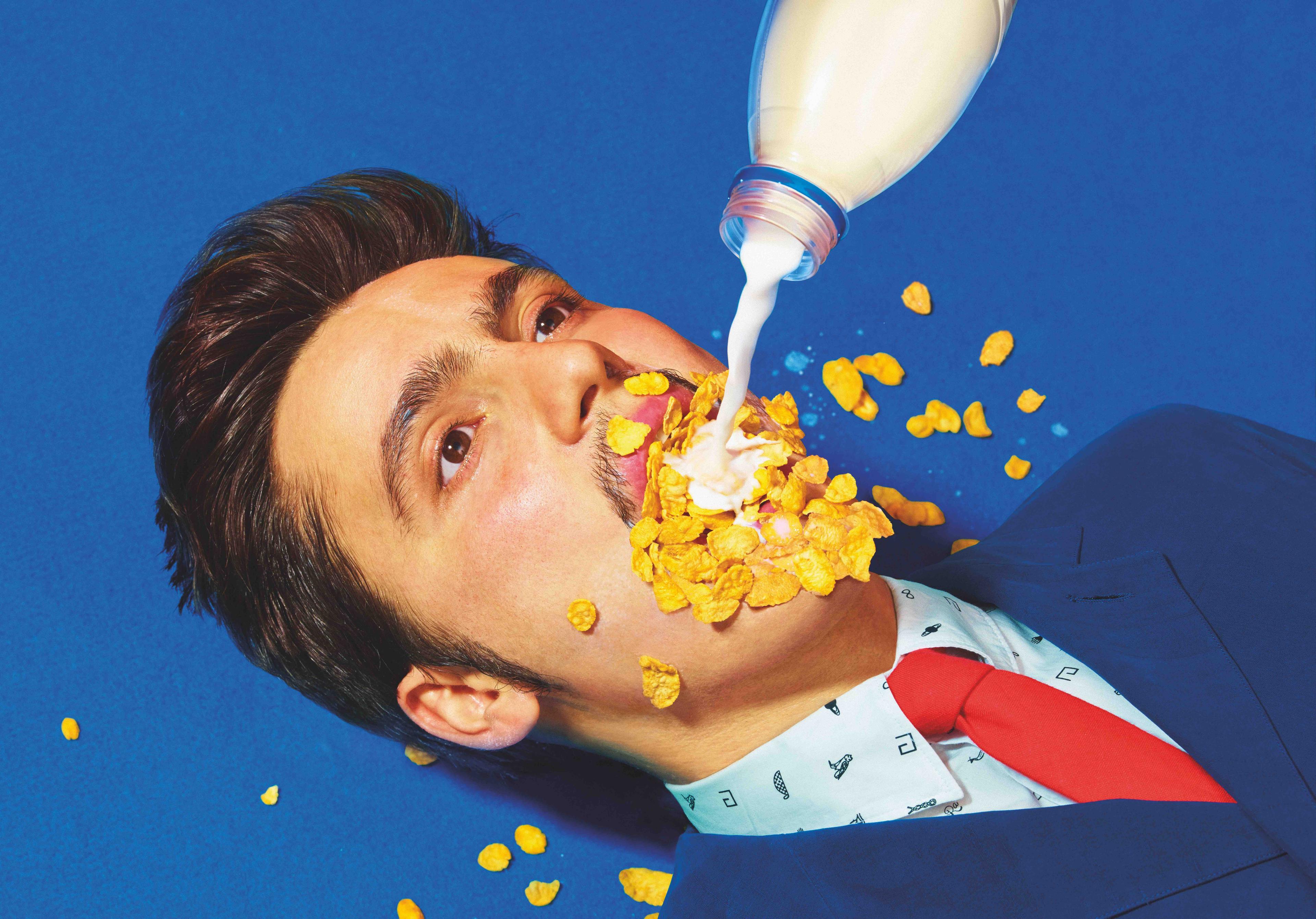 an image of cereal and milk being poured into a man's mouth