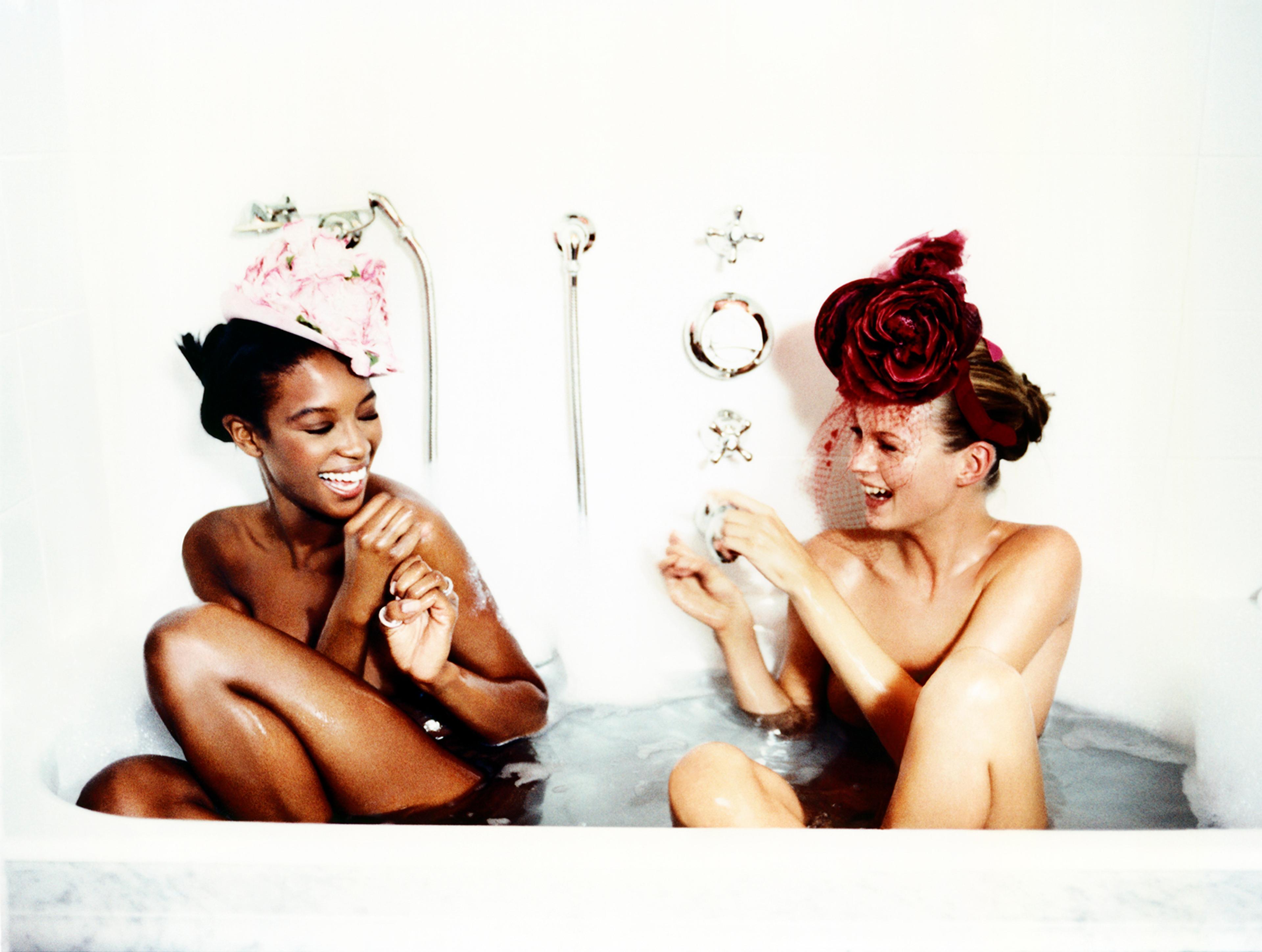 A photograph of two laughing women sharing a bath