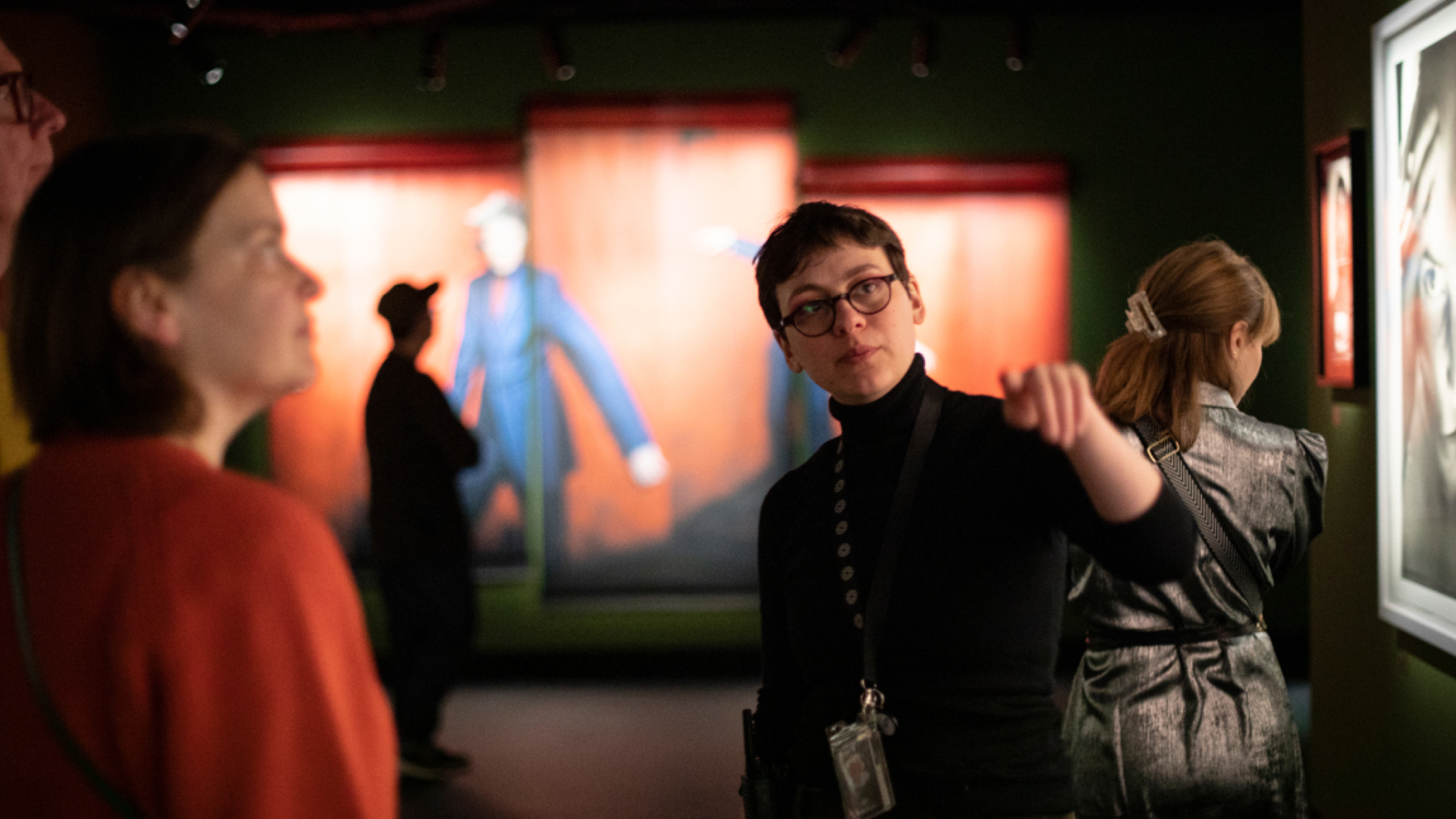 Person in an exhibtion hall showing artworks to visitors