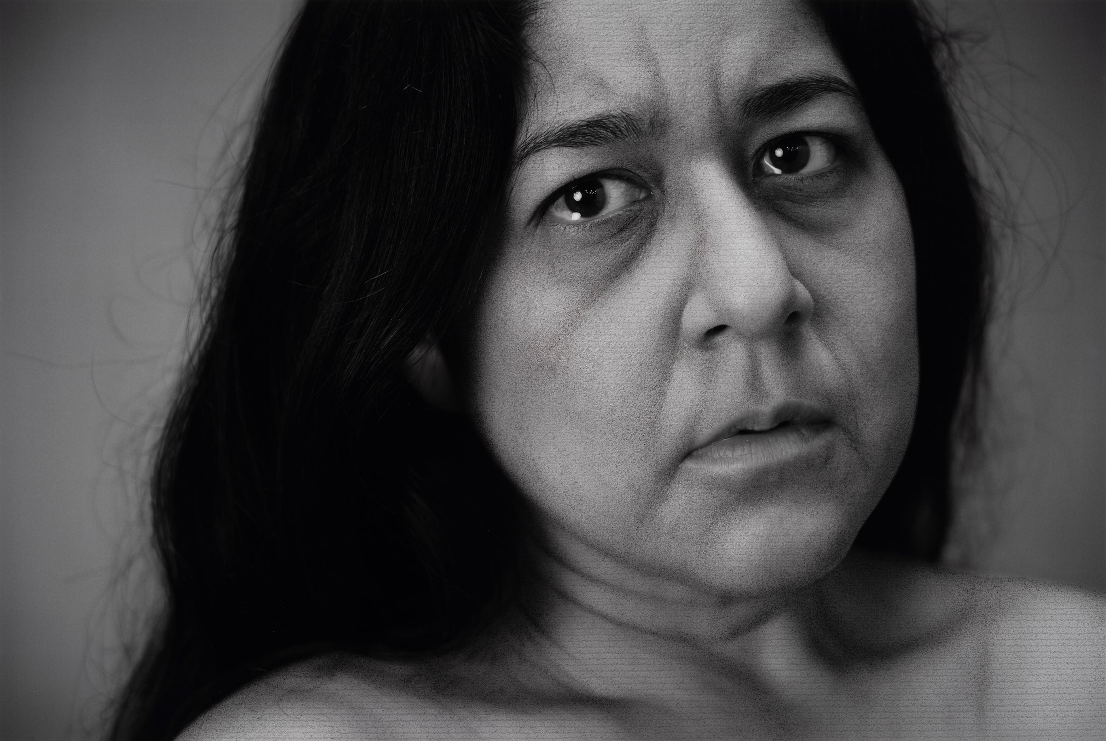 A black and white portrait of a woman, looking concerned into the camera.