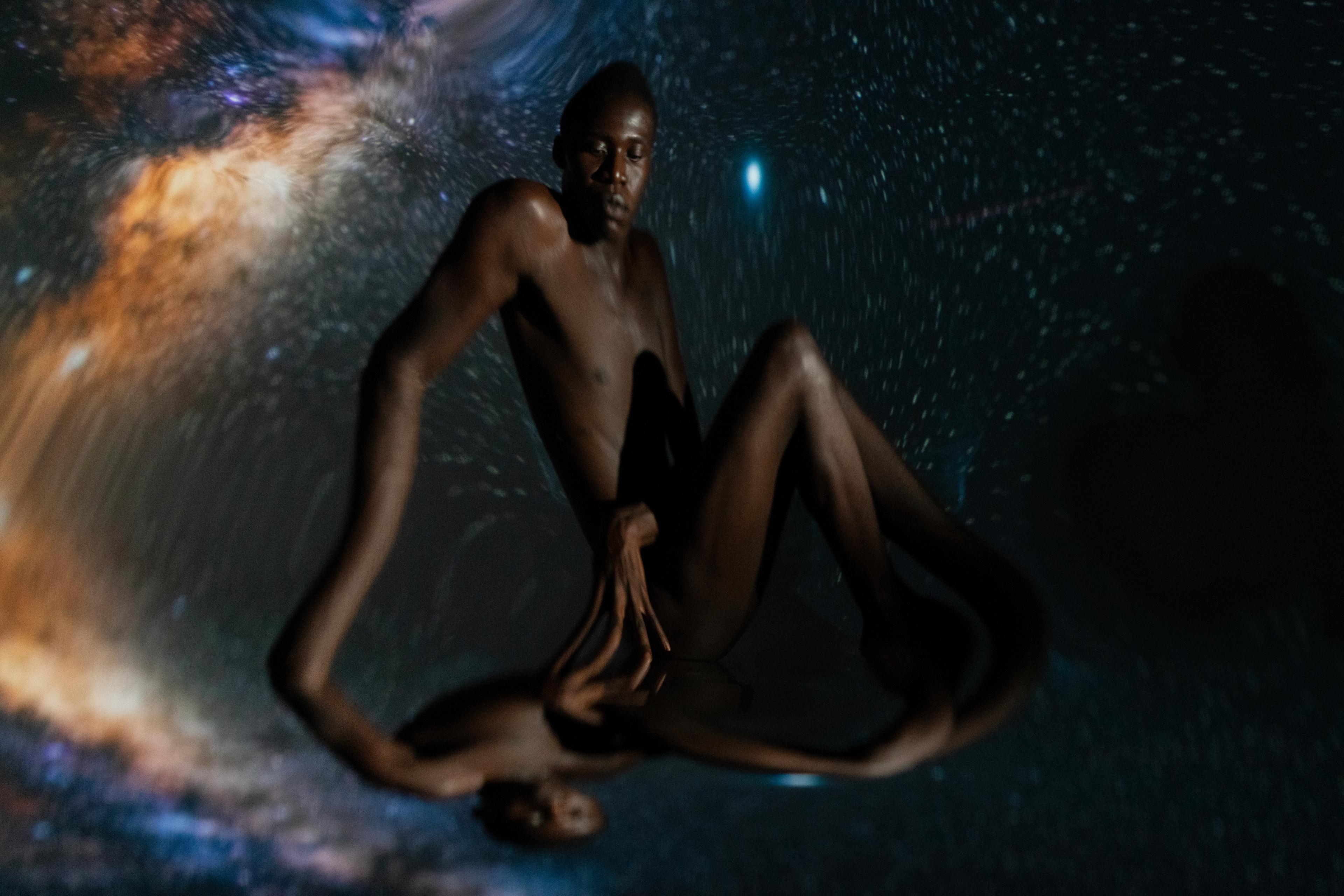 A naked man with space-background and a kaleidoscopic effect over the photograph
