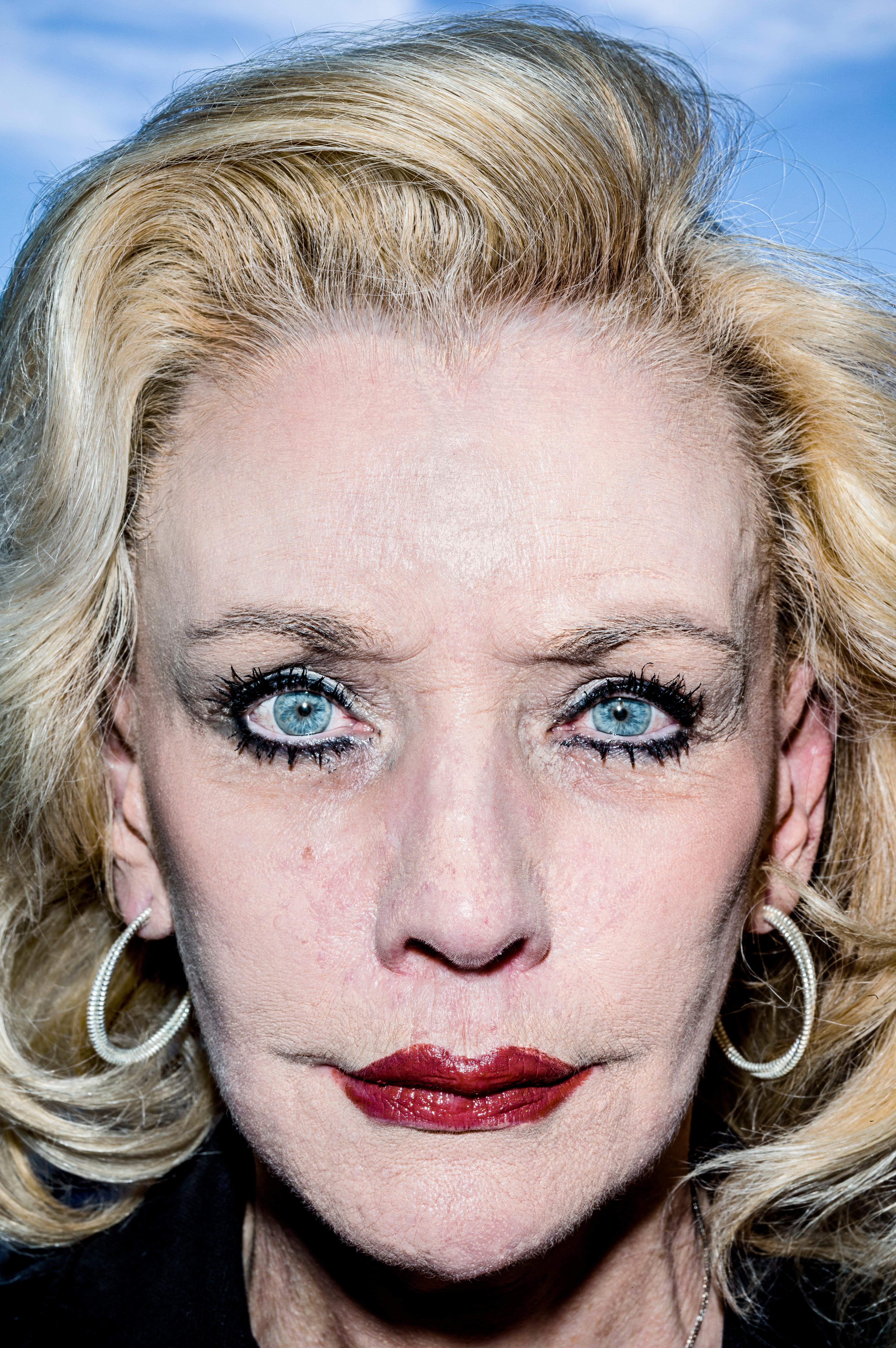 Close up portrait image of a women with voluminous blonde hair and face with make-up