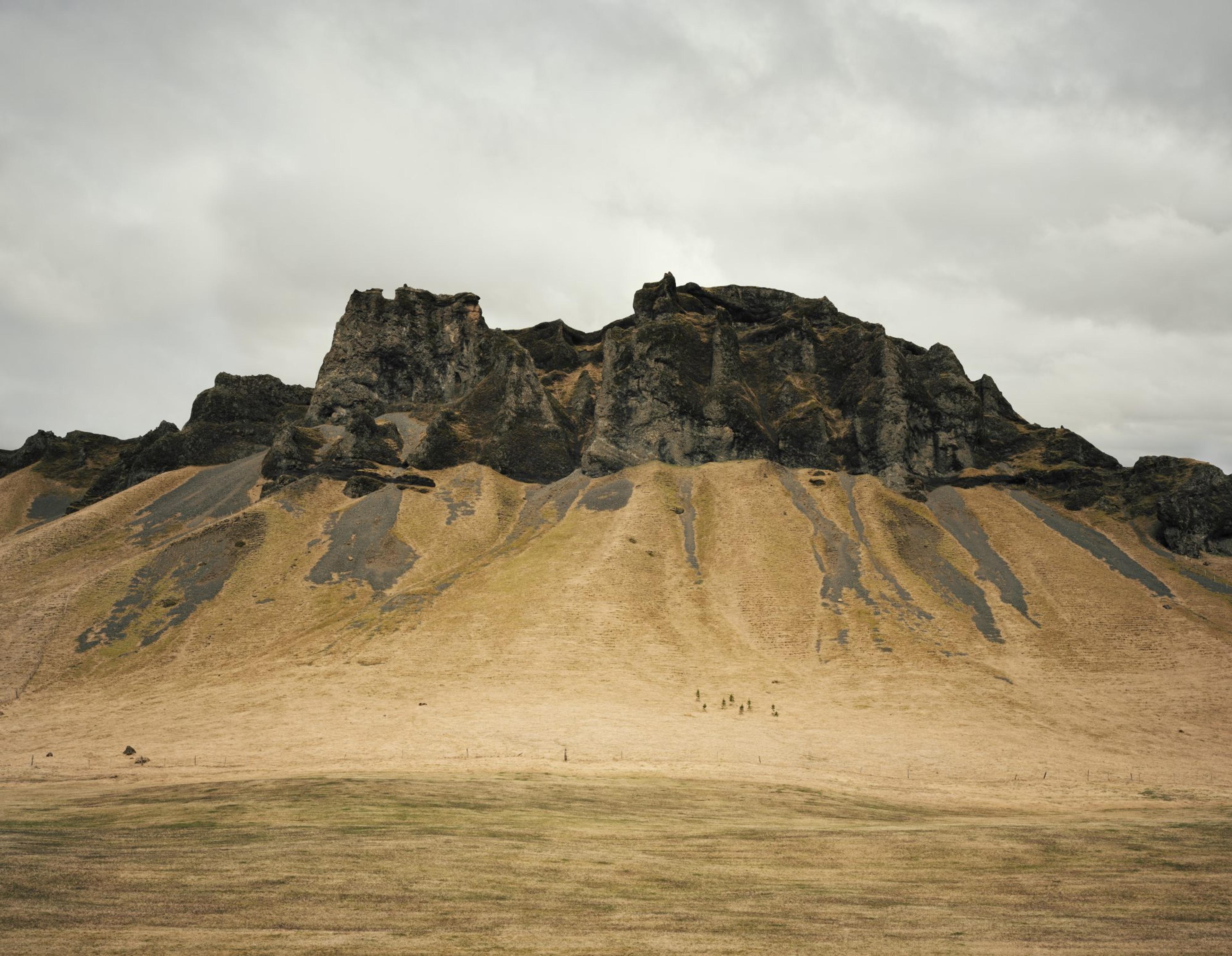 A photograph of a cloudy, mountainous desert landscape