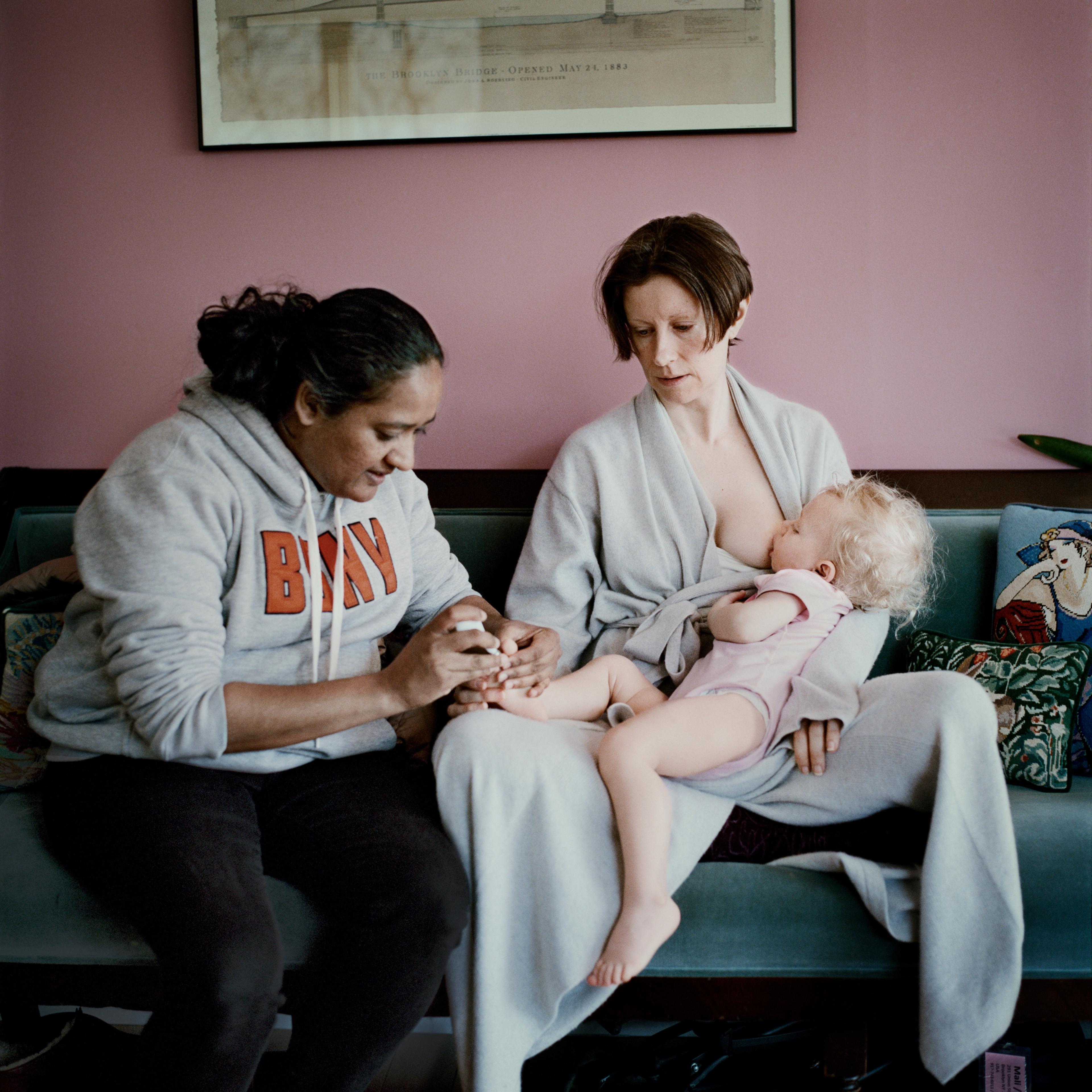 A photograph of a mother and child being groomed by a woman in their apartment