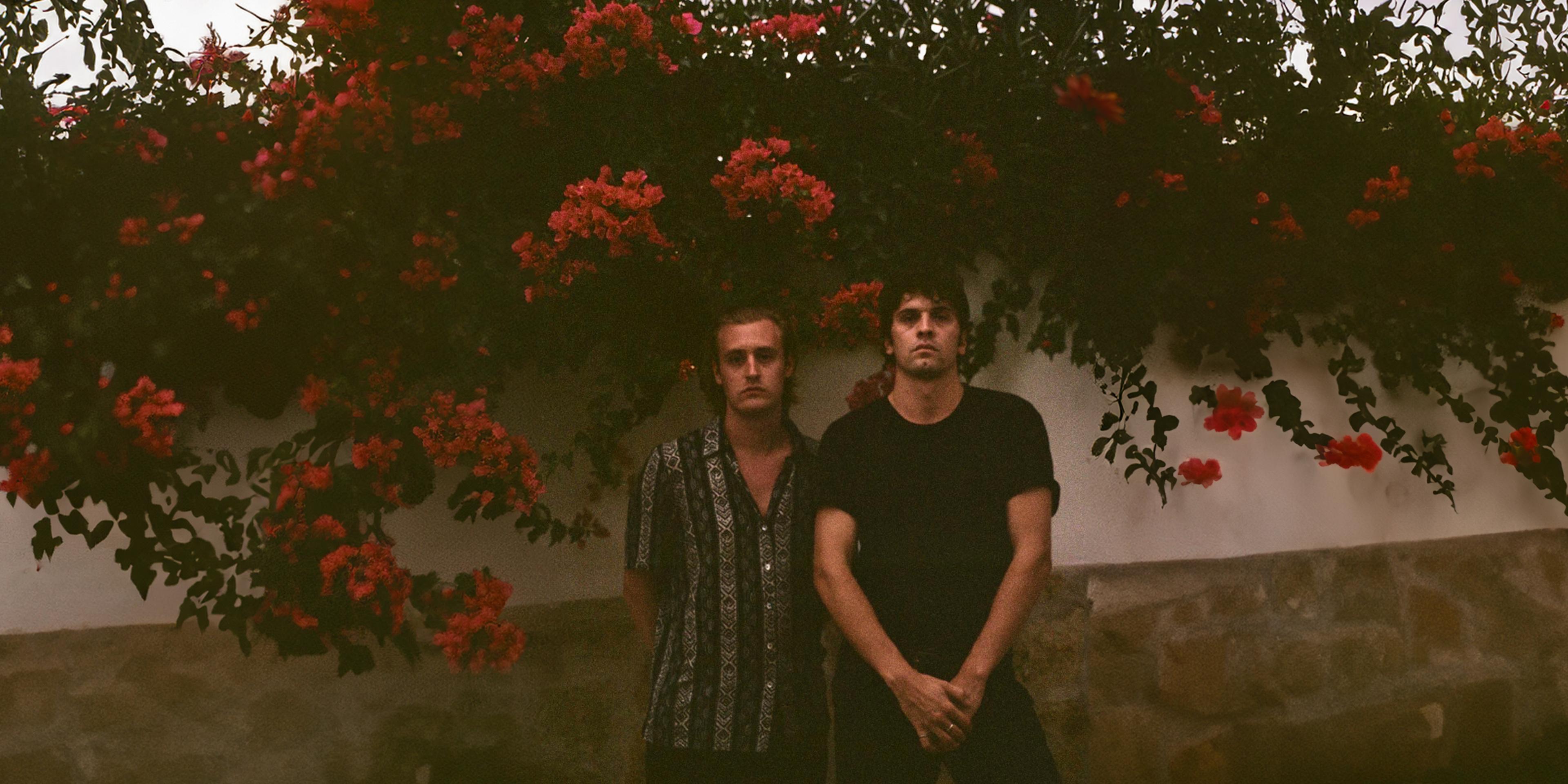 A picture of two people with red roses in the background.