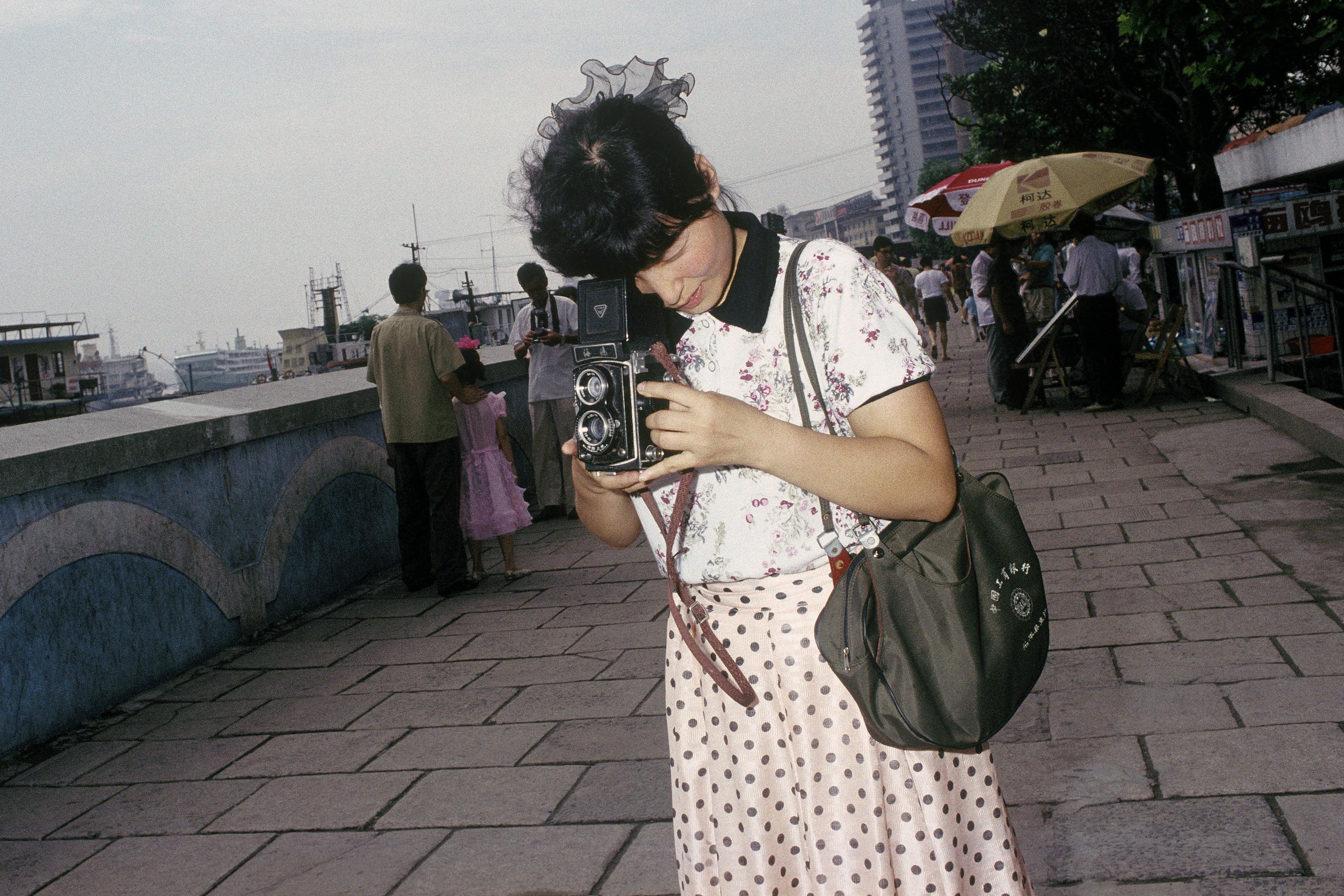 With her Seagull camera on the old bund©️Robert Van Der Hilst, 1990