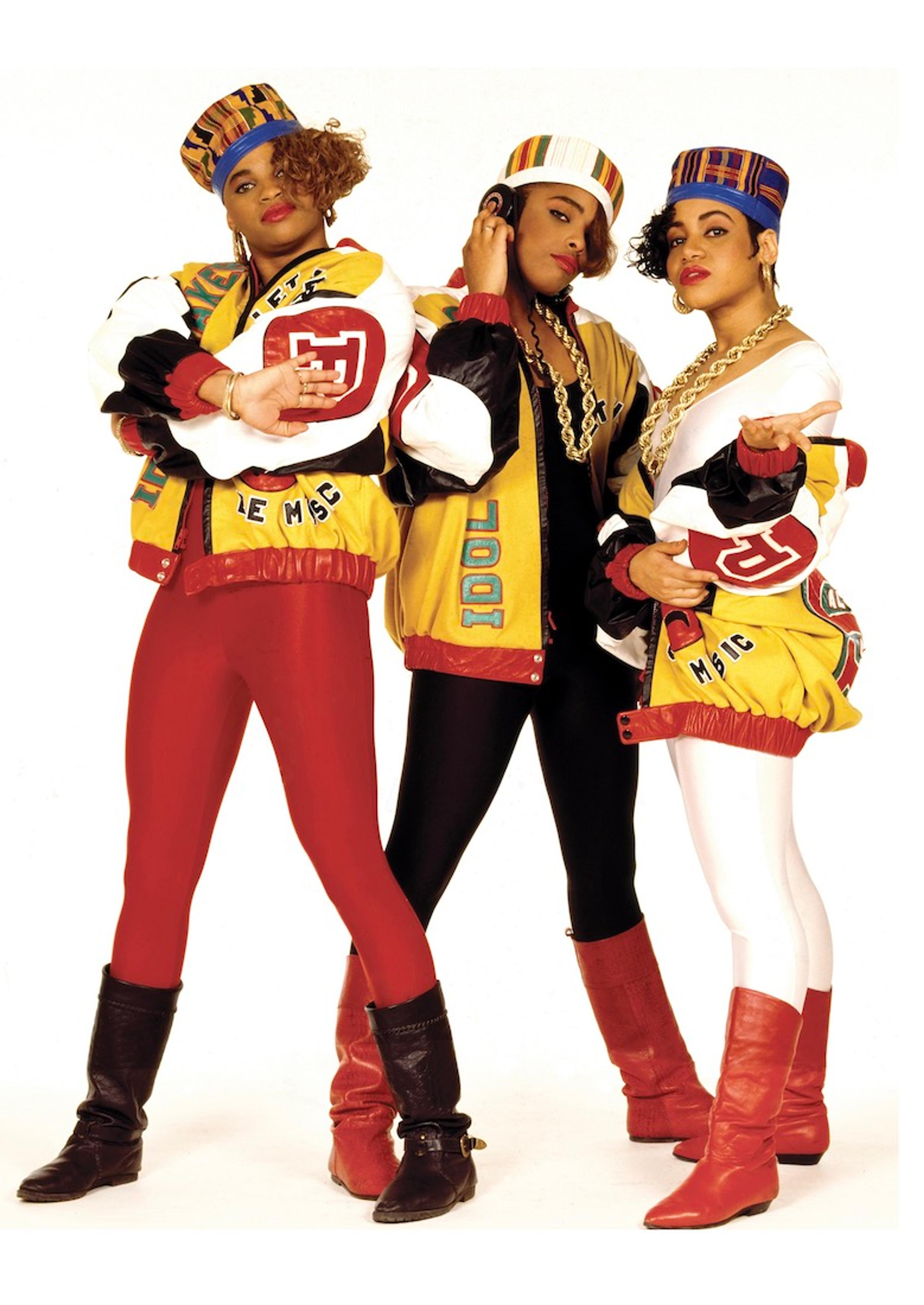 A photograph of the Salt-n-Pepa trio dressed in yellow and red outfits