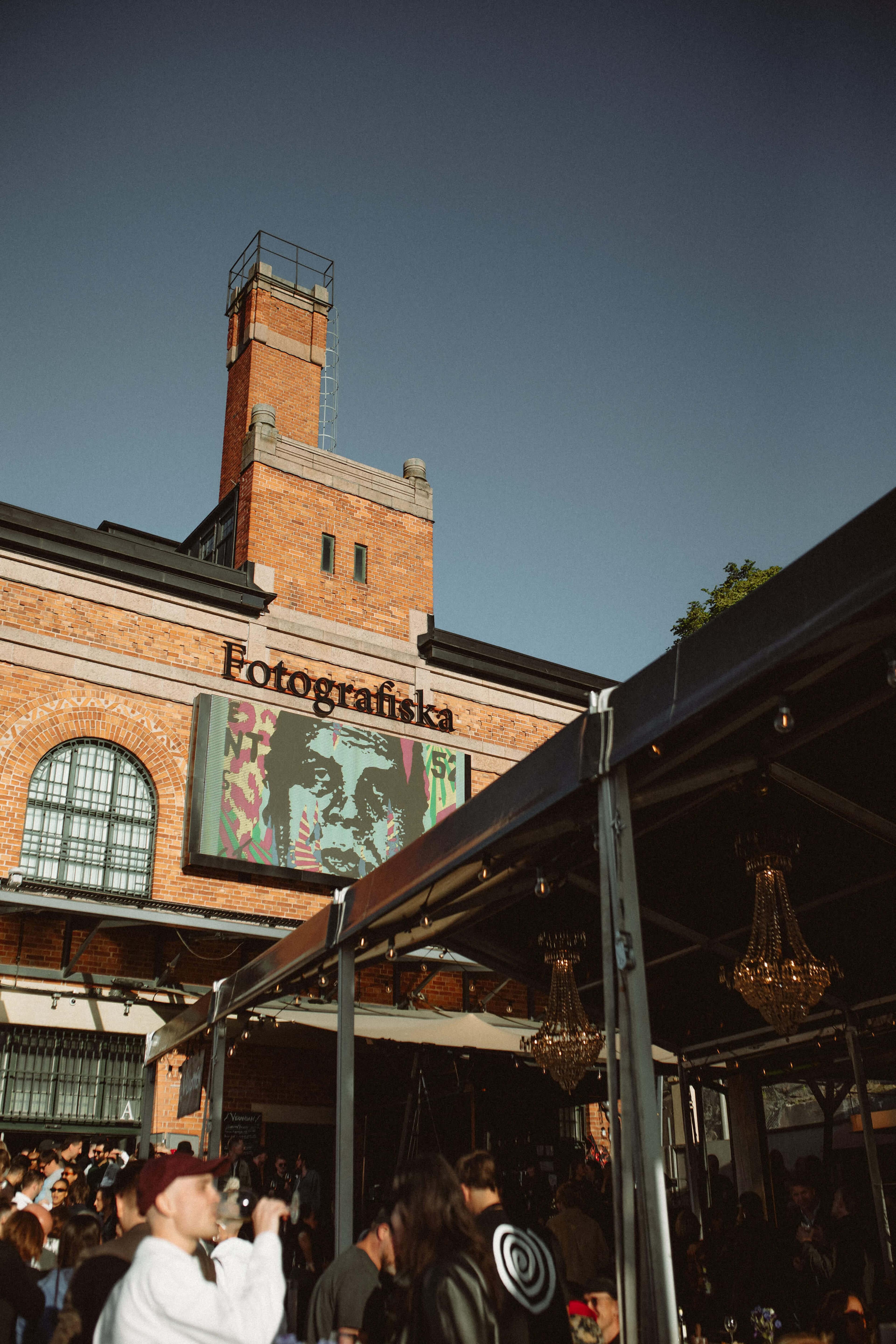 Fotografiska Stockholm exterior with view over the outdoor veranda where people are mingling