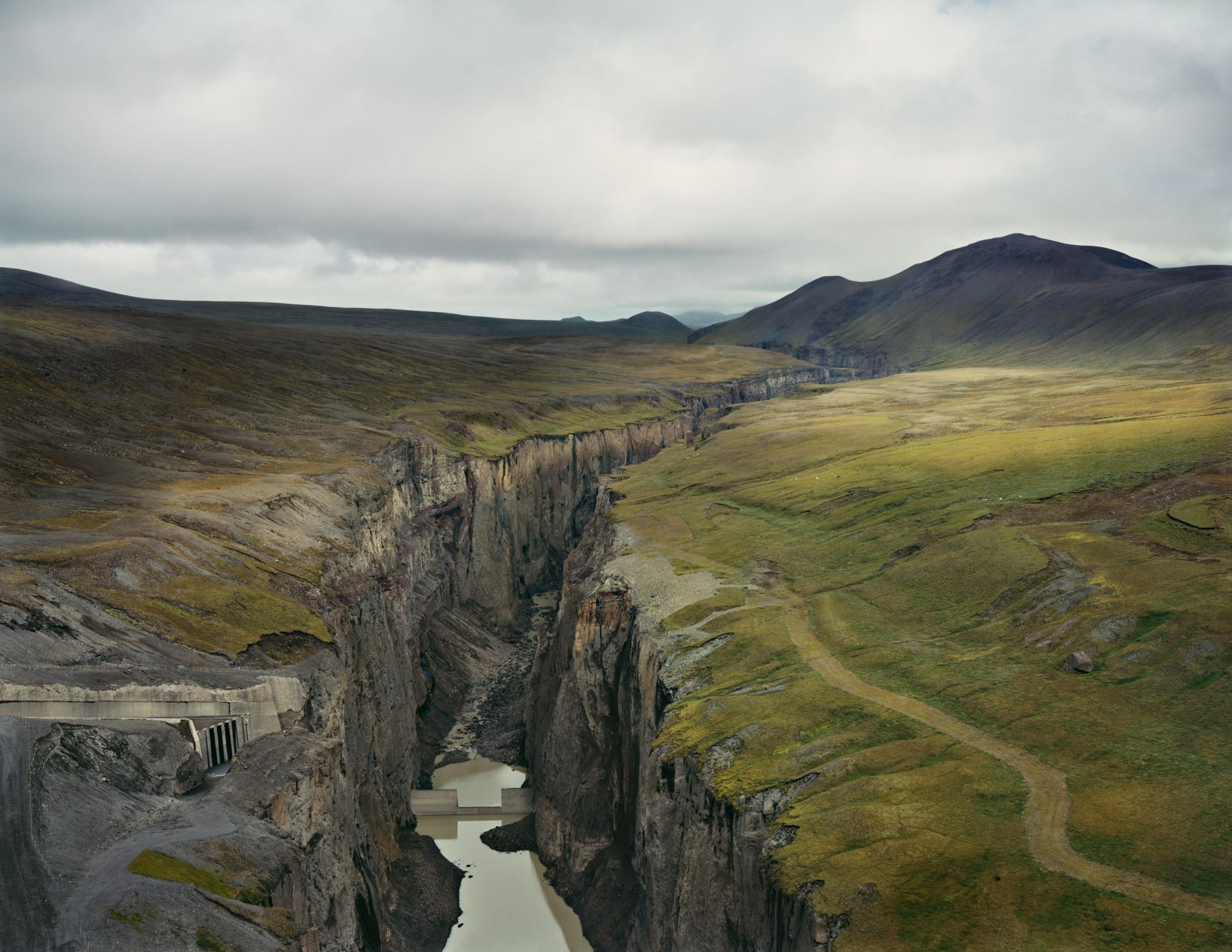 A moody photograph of a cloudy, mountainous landscape