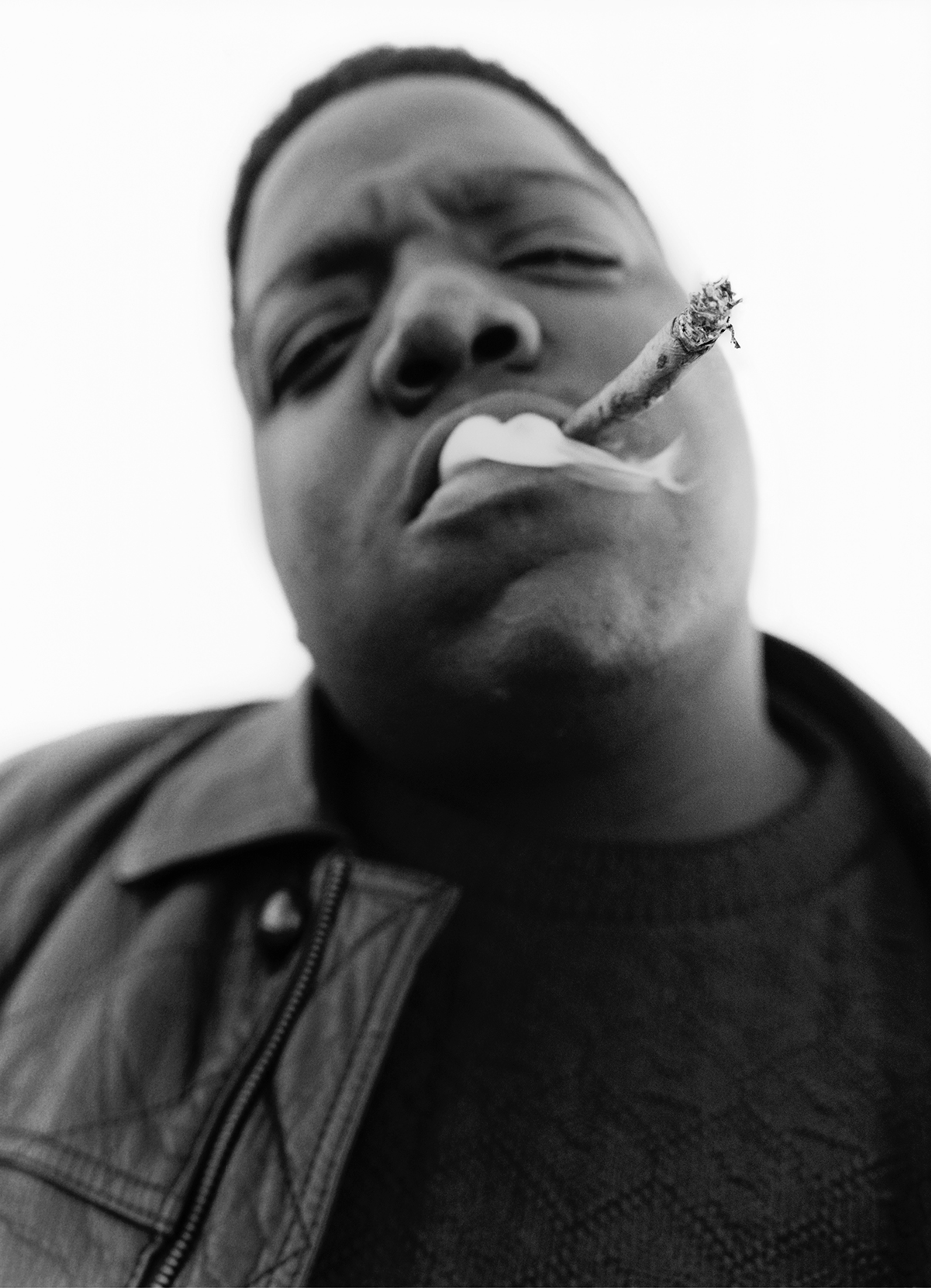 A black and white portrait of Notorious B.I.G. smoking