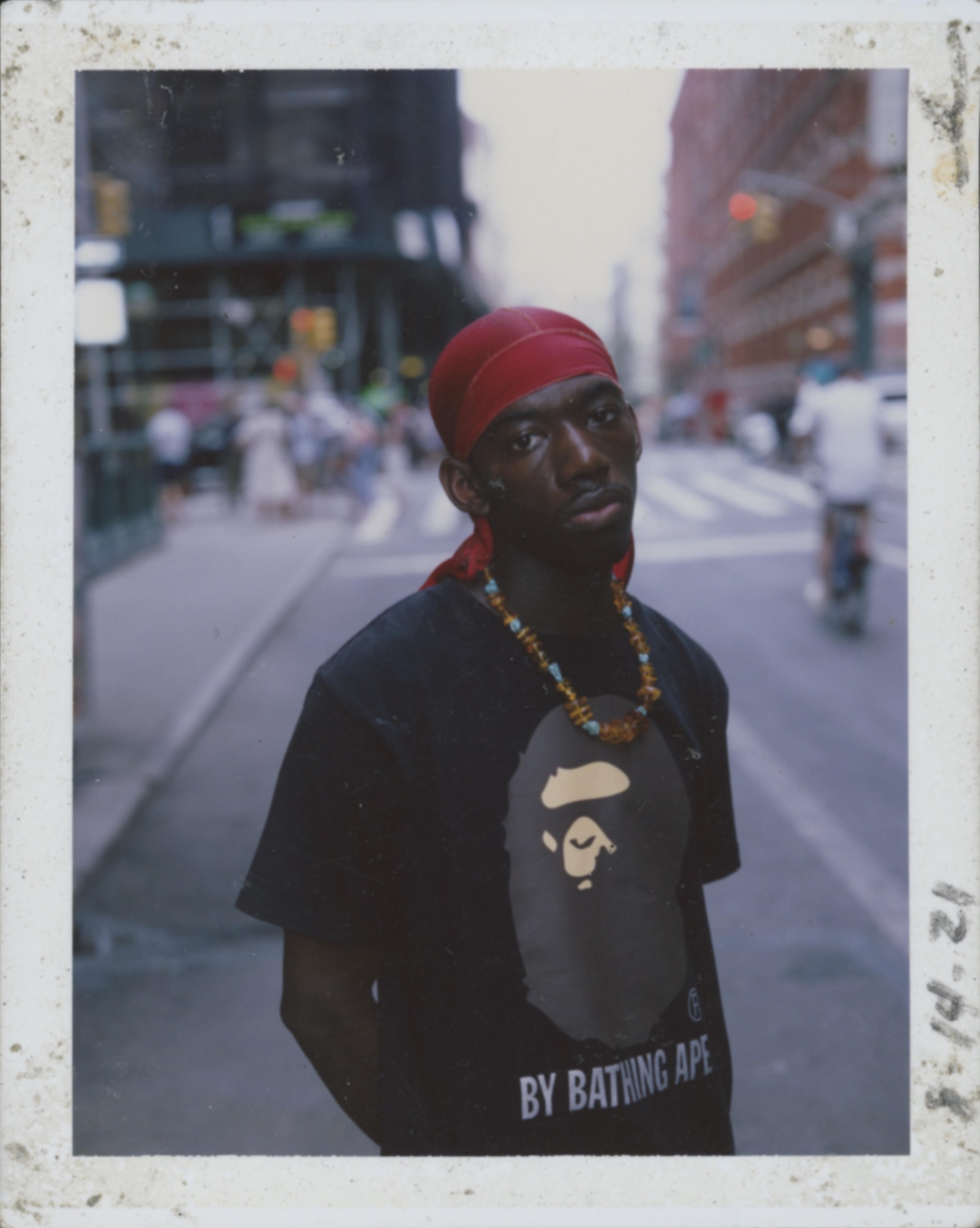 A man wearing a red head wrap and black t-shirt with a gorilla graphic