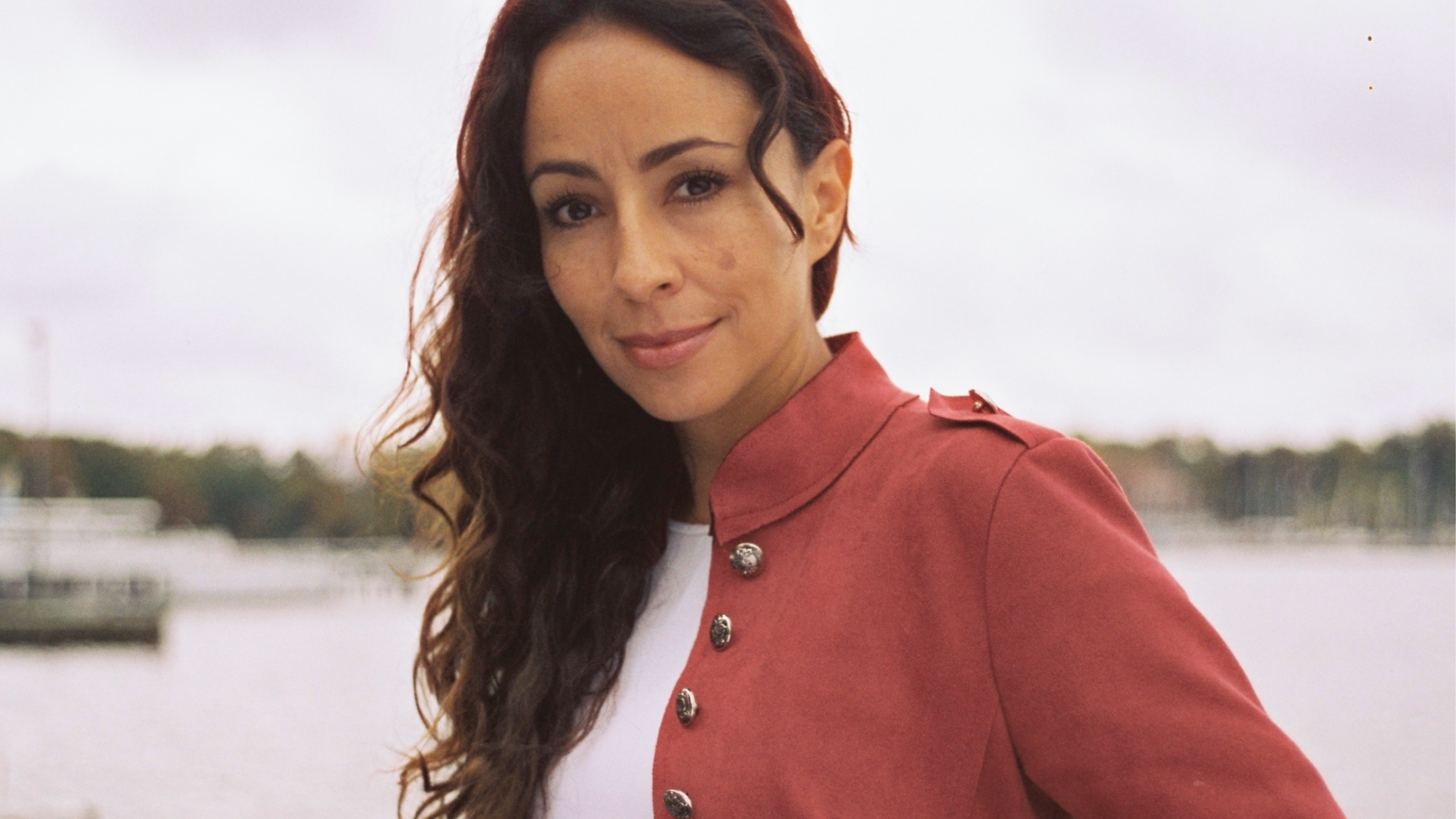 Woman with brown hait and a red jacket.