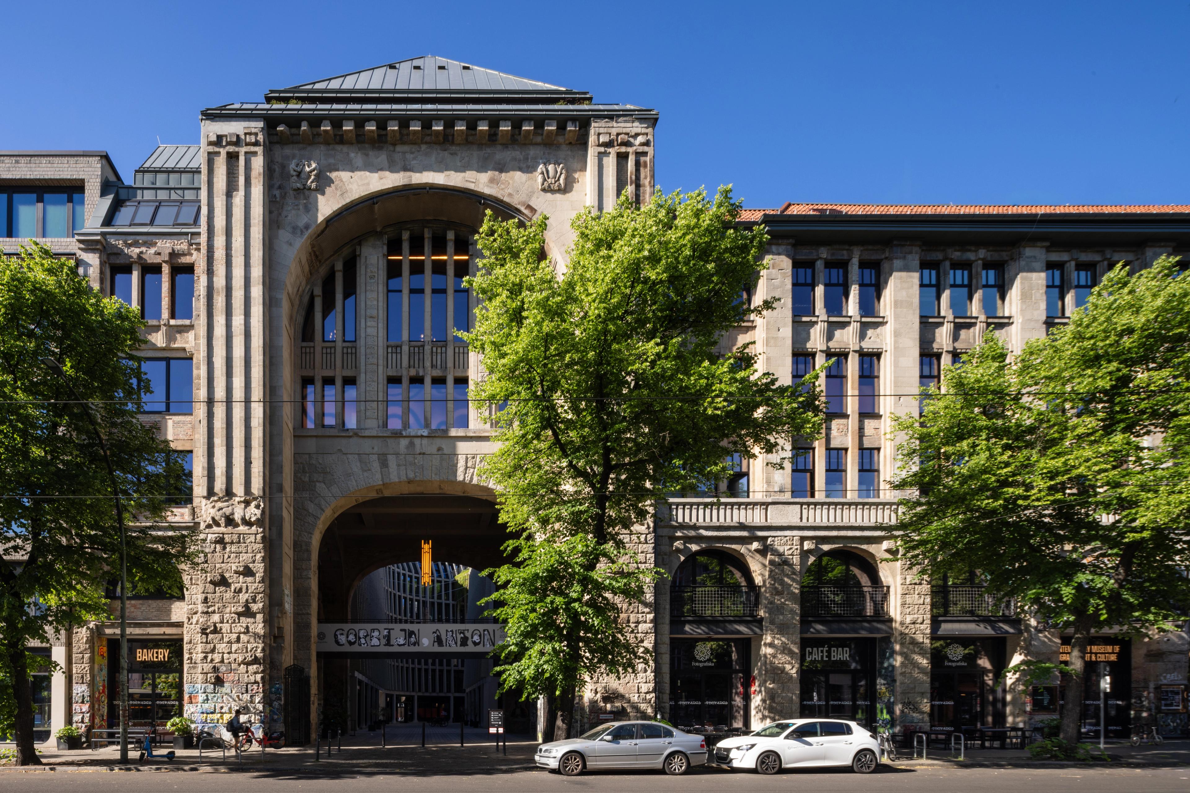 Photograph of a large building with many windows and people.