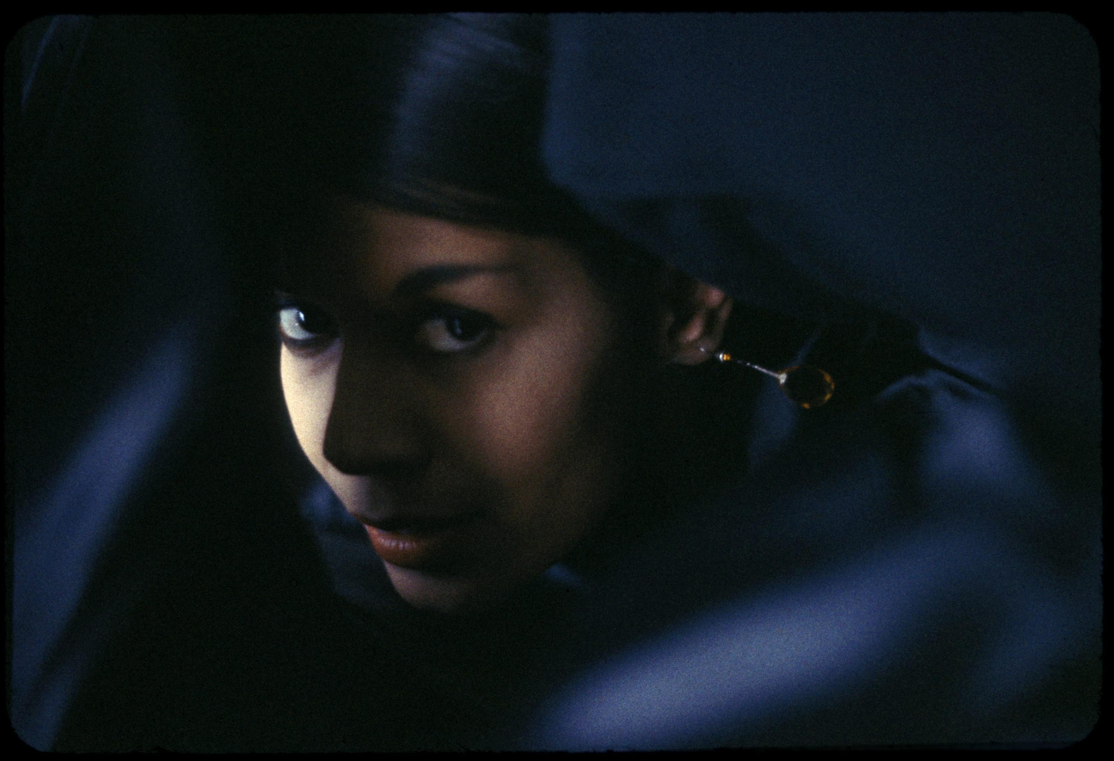 A close-up portrait of Carmen de Lavallade in dark lighting