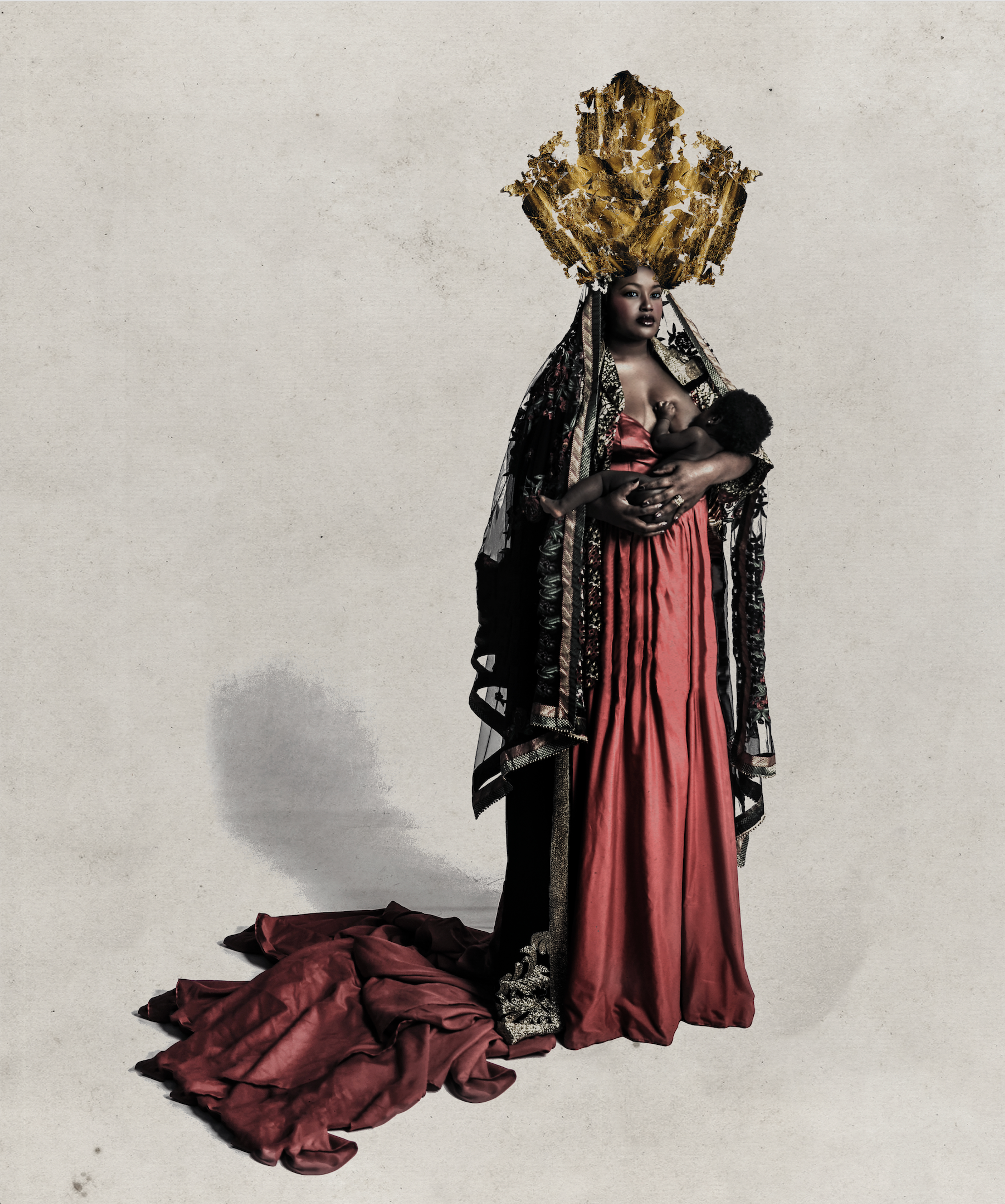 A woman wearing an ornate headdress and red dress holding a child