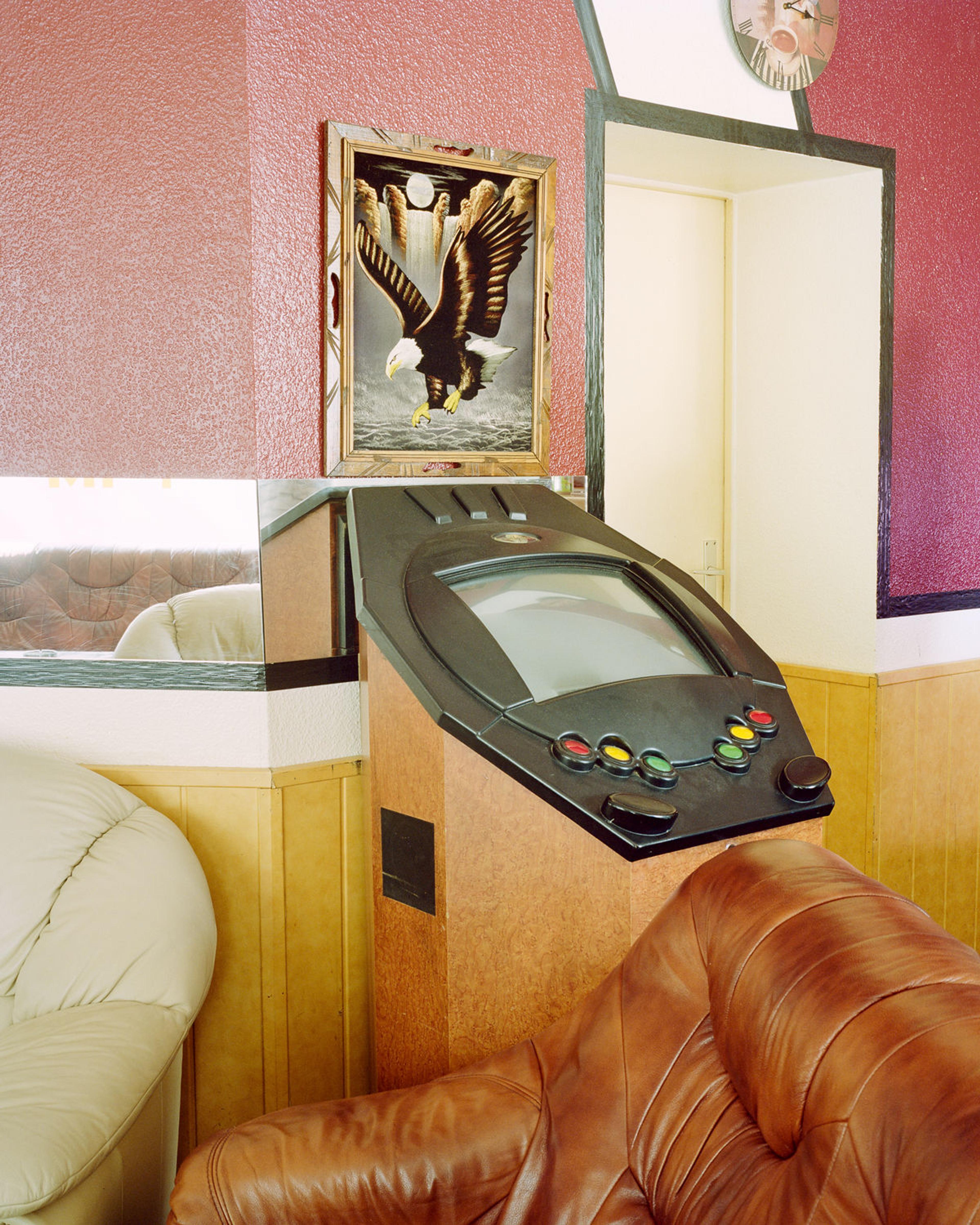 A slot machine in front of a picture of an eagle.