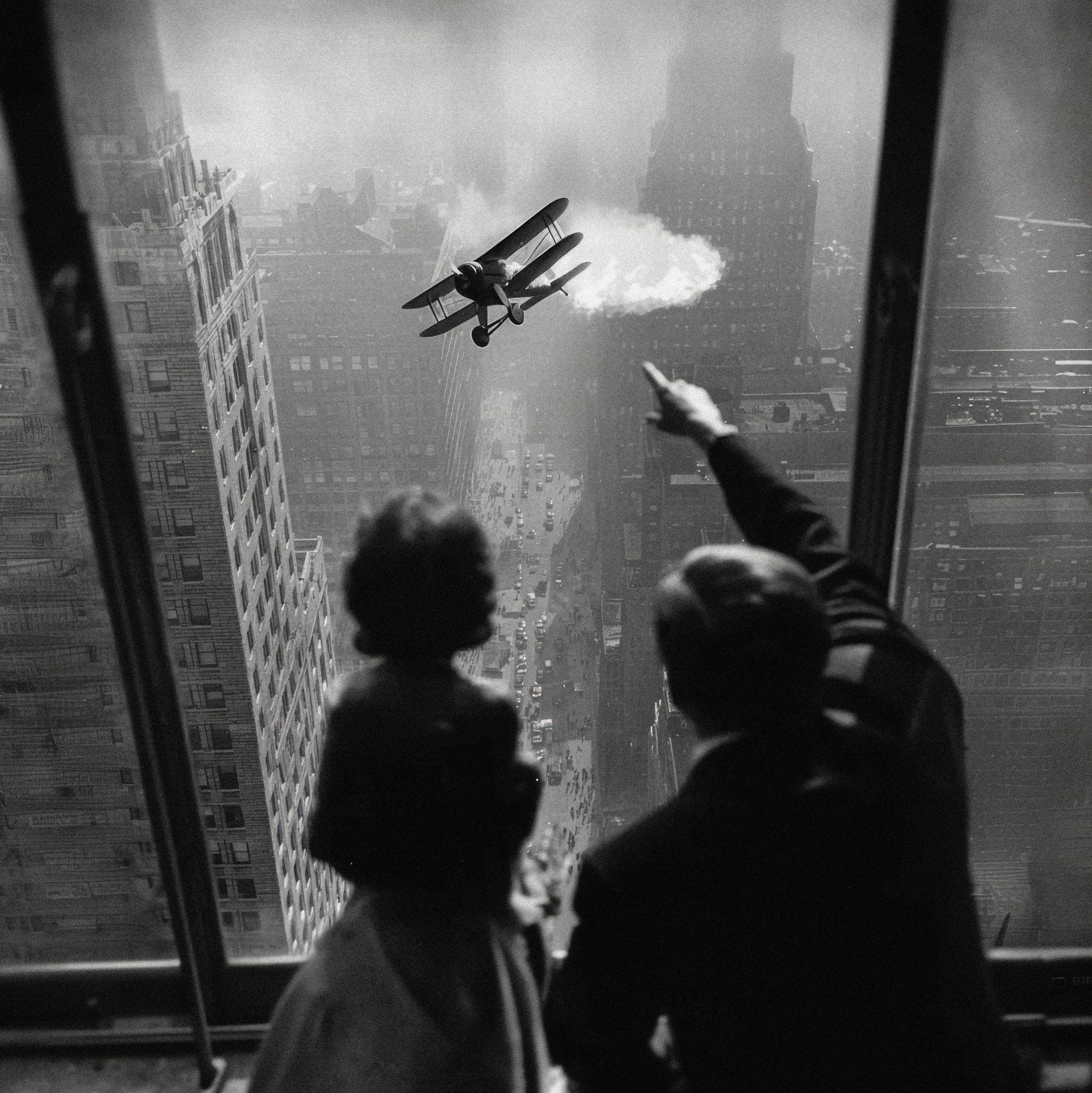 Mann und eine Frau die aus einem Wolkenkratzerfenster auf ein Flugzeug zeigen