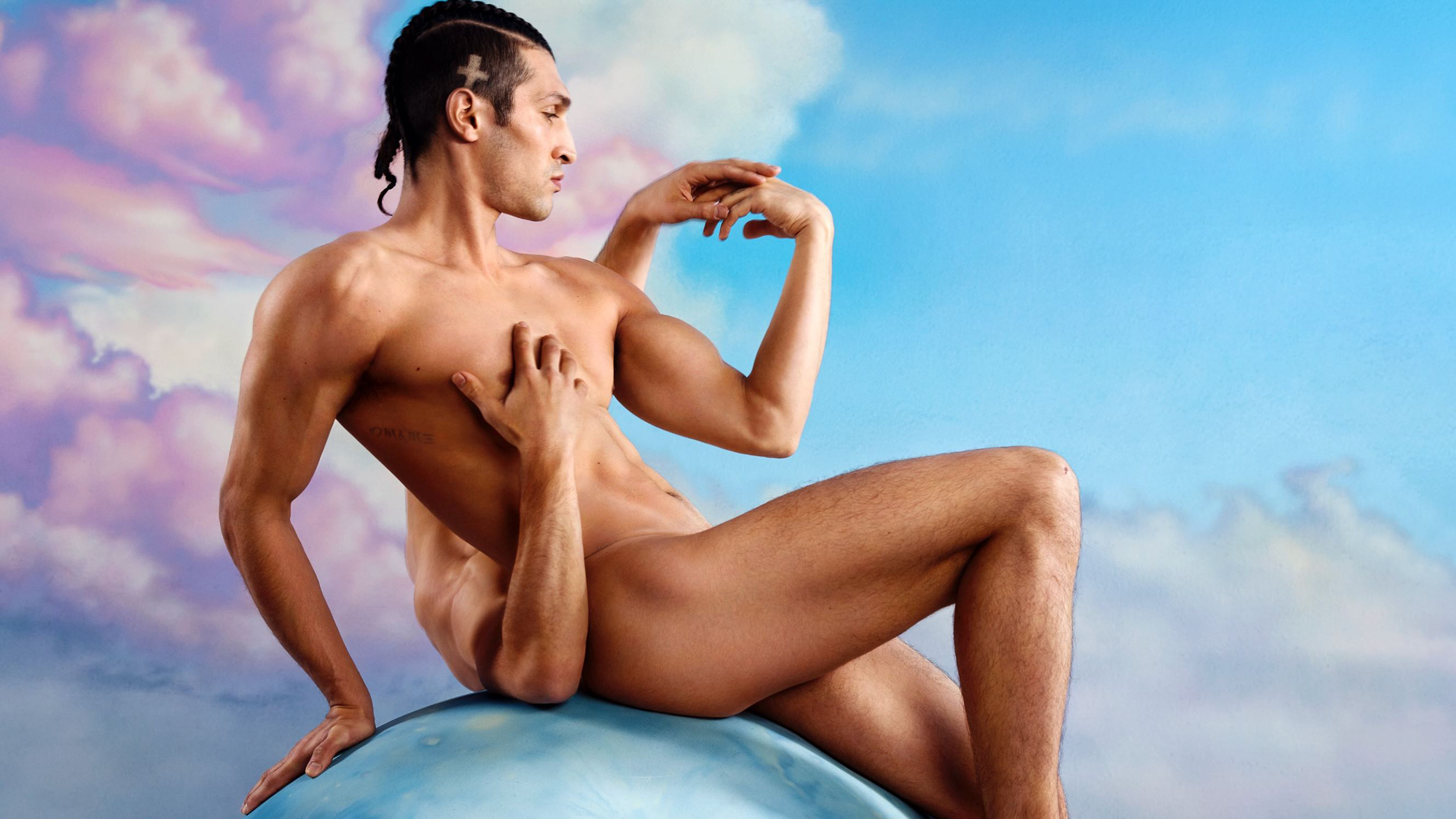 A photographic artwork of two nude men artistically posed on a blue sphere, with a vibrant sky in the background