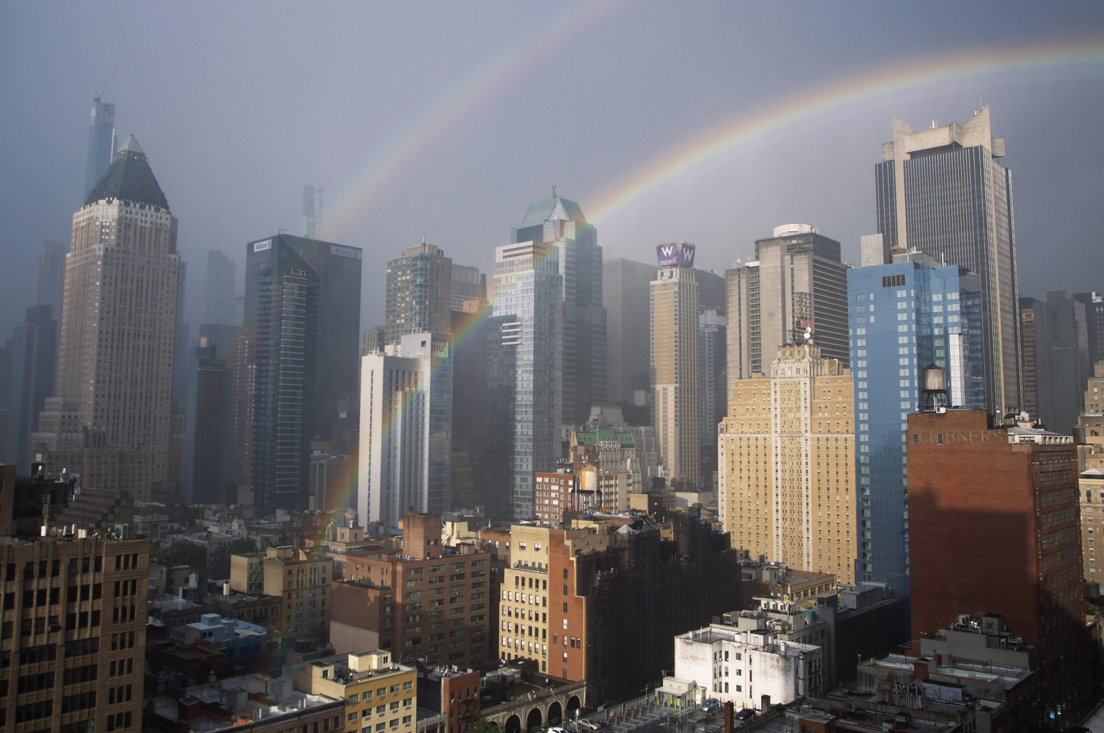 A photograph of the New York skyline featuring a double rainbow