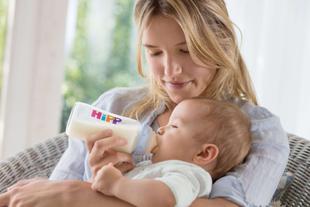 Eine Frau füttert ihr Baby mit einer Hipp-Flasche.