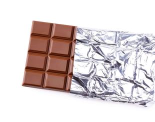 Ein Schokoladenriegel, der teilweise in Aluminiumfolie eingewickelt ist.