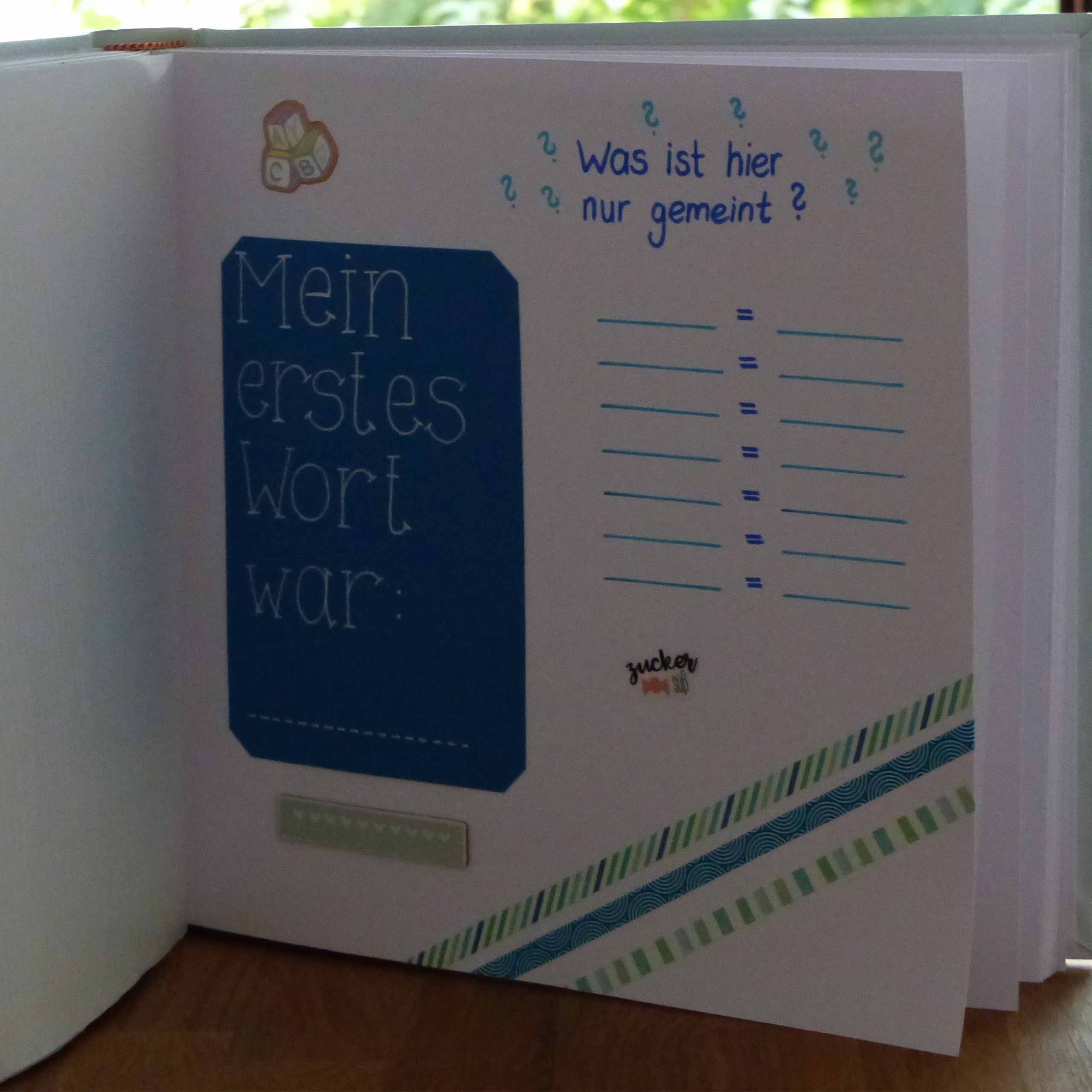 Eine Seite aus einem Notizbuch mit blauem Hintergrund, auf der eine Liste mit der Überschrift "Mein erstes Wort war:", gefolgt von einer Liste von Wörtern und einer kleinen Illustration eines Menschen und eines Hundes zu sehen ist.