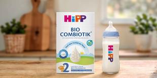 HiPP 2 BIO Combiotik® ohne Stärke Folgemilch-Packung mit gefüllter Babyflasche auf Holztisch in heller Küche