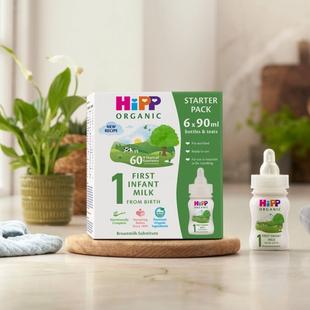 HiPP Organic ready to feed infant starter pack next to a bottle of milk on a kitchen worktop