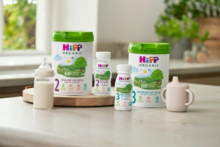 HiPP Organic Stage 2 Follow On Milk and Stage 3 Growing Up Milk tubs and ready-to-feed bottles on a kitchen counter.