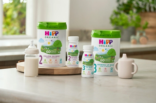 HiPP Organic follow on milks next to and on top of a delivery box outside the front door of a house