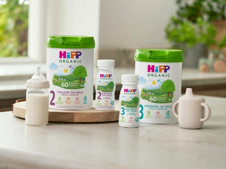 HiPP Organic follow on milks next to and on top of a delivery box outside the front door of a house
