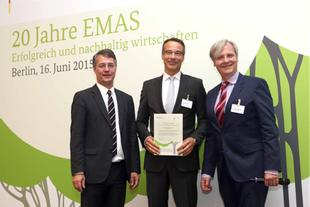 Drei Männer im Anzug bei der Feier „20 Jahre EMAS“ in Berlin, der HiPP Vertreter hält die EMAS-Urkunde für nachhaltiges Umweltmanagement.