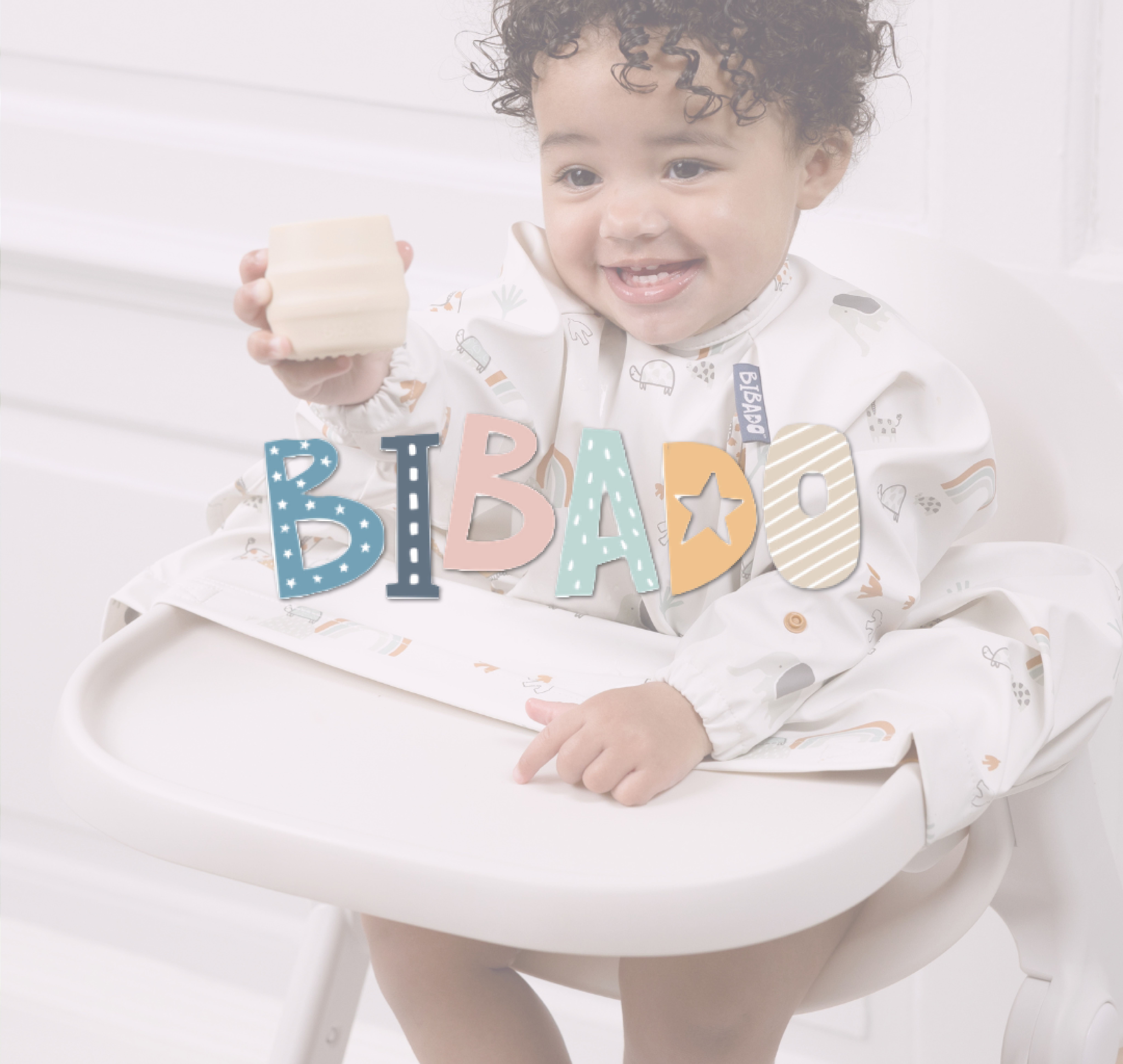 Baby smiling in a highchair wearing a Bibado coverall weaning bib and holding a cup, with the Bibado logo overlaid on the image.