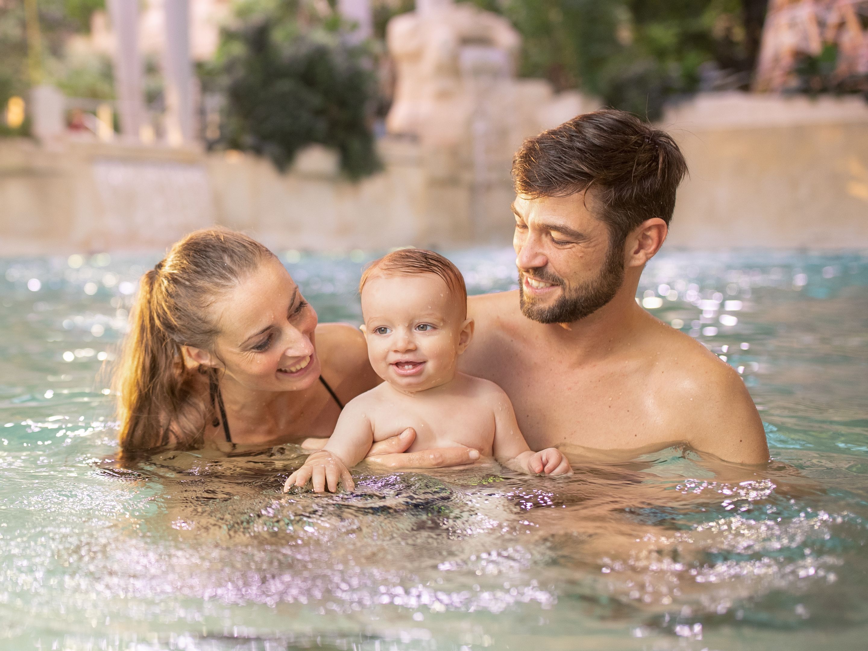 Familie im Wasser mit Baby